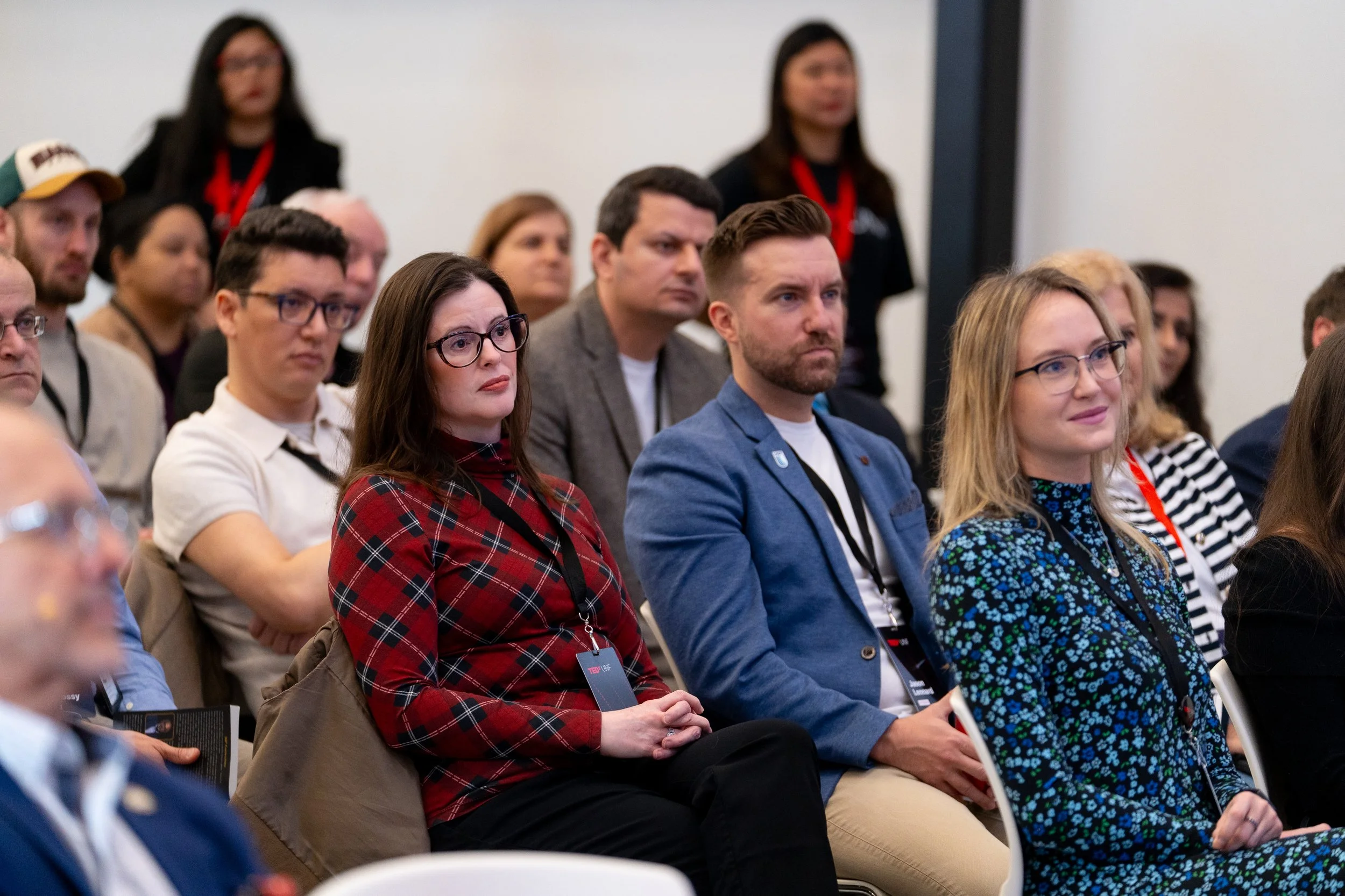 Audience attending a conference, sitting in rows, listening attentively.