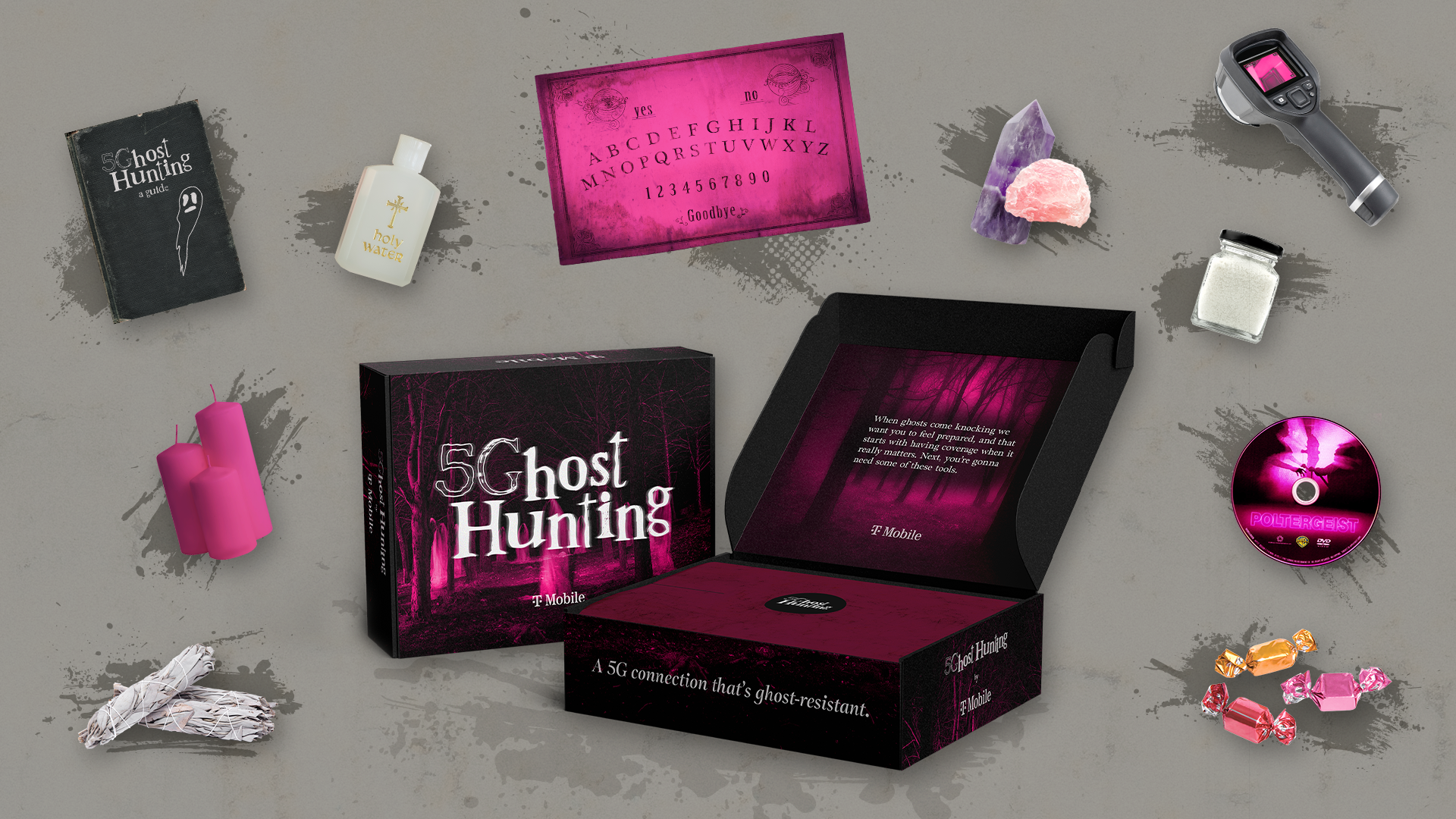 A collection of items related to ghost hunting and paranormal investigation, including a black book titled 'Ghost Hunting', a white bottle labeled 'holy water', a pink Ouija board with yes, no, and alphabet, a purple and pink crystal, a handheld EMF meter, a small jar of salt, pink candles, a DVD titled 'Poltergeist', a black and pink box of 'Ghost Hunting' equipment, a black case with text about ghosts and technology, a pile of sealed candies, a bundle of sage, and some loose candies on a grey surface with paint splatters.