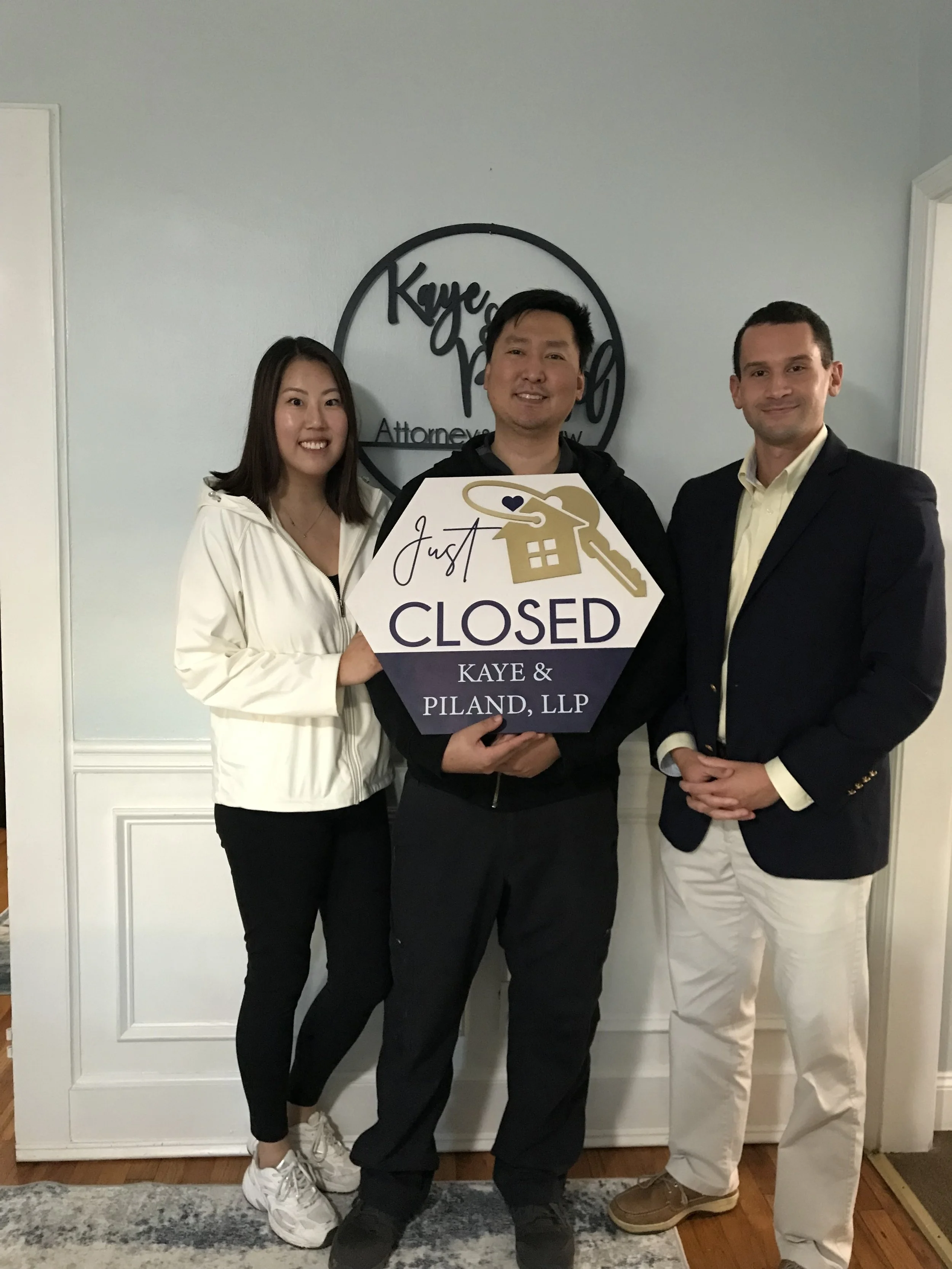 Client and real estate agent Cameran Jaques holding a closed sign