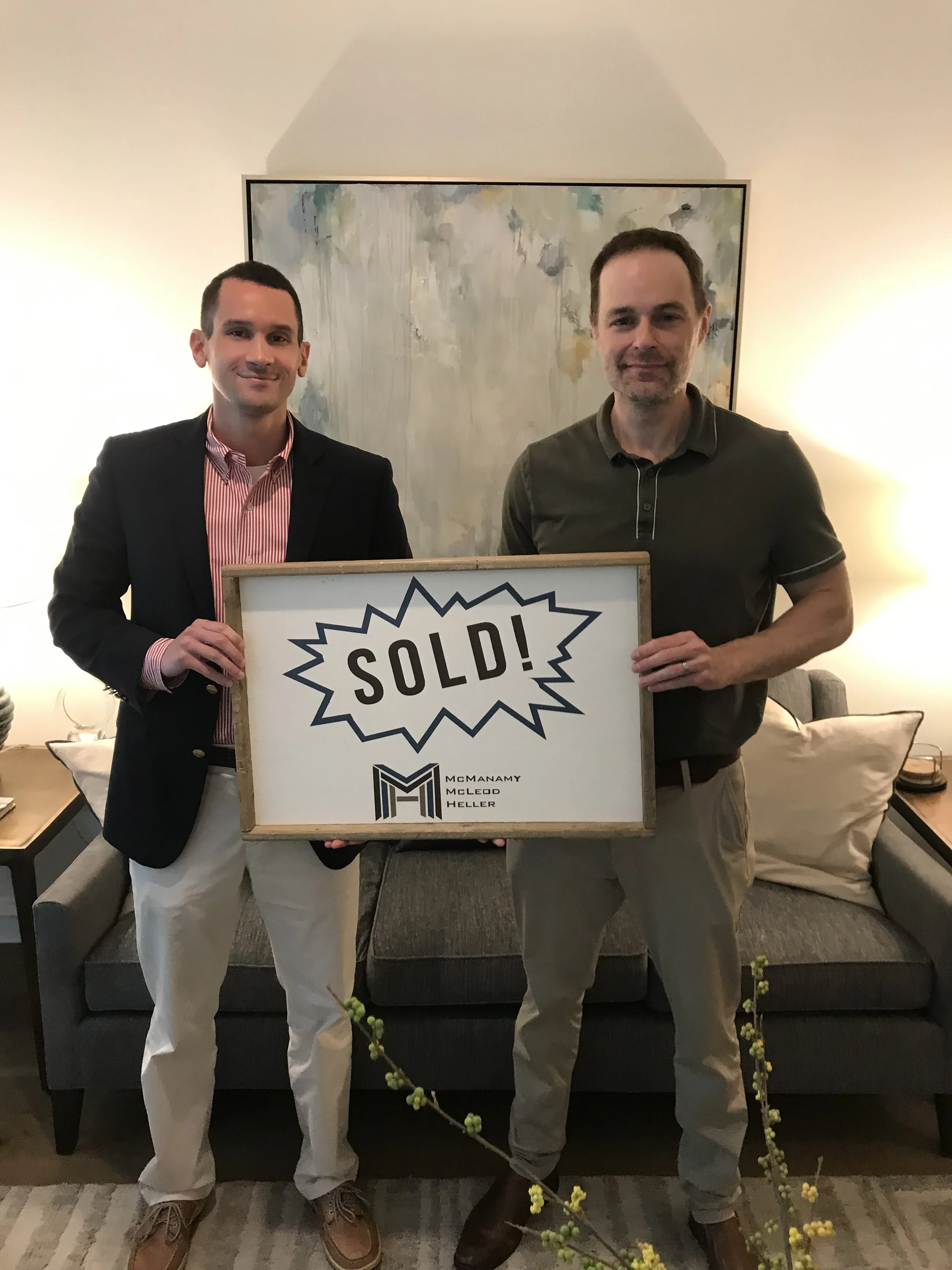 Cameran Jaques celebrating a home sale with a client holding a sold sign