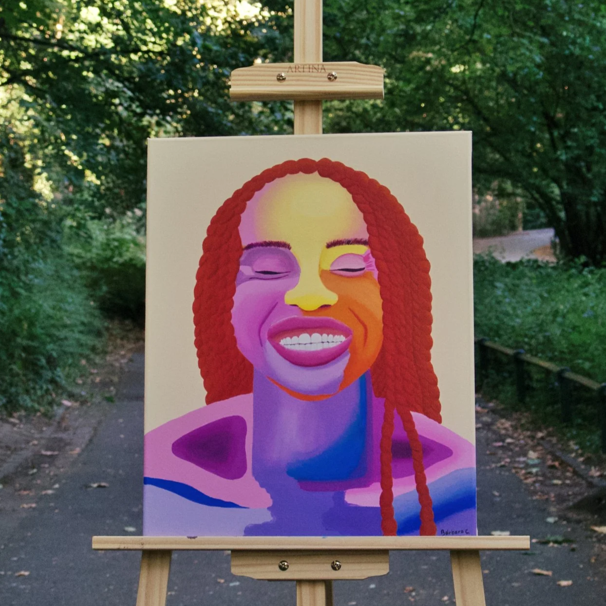Colorful painting of a smiling woman with red braided hair, closed eyes, and a peaceful expression, set against an abstract background with purple, pink, and orange hues.