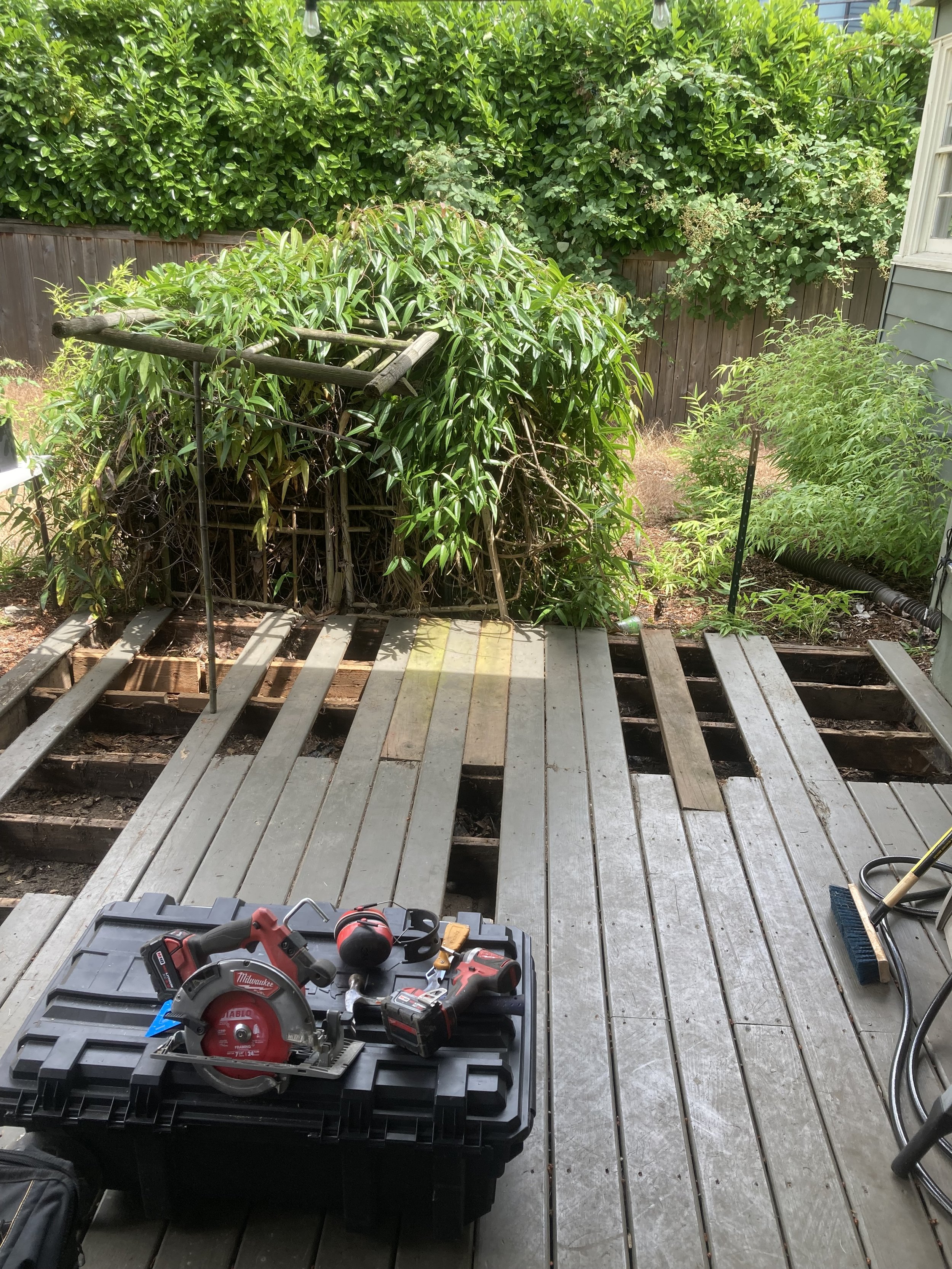 A deck with some of the board removed and tools scattered about.