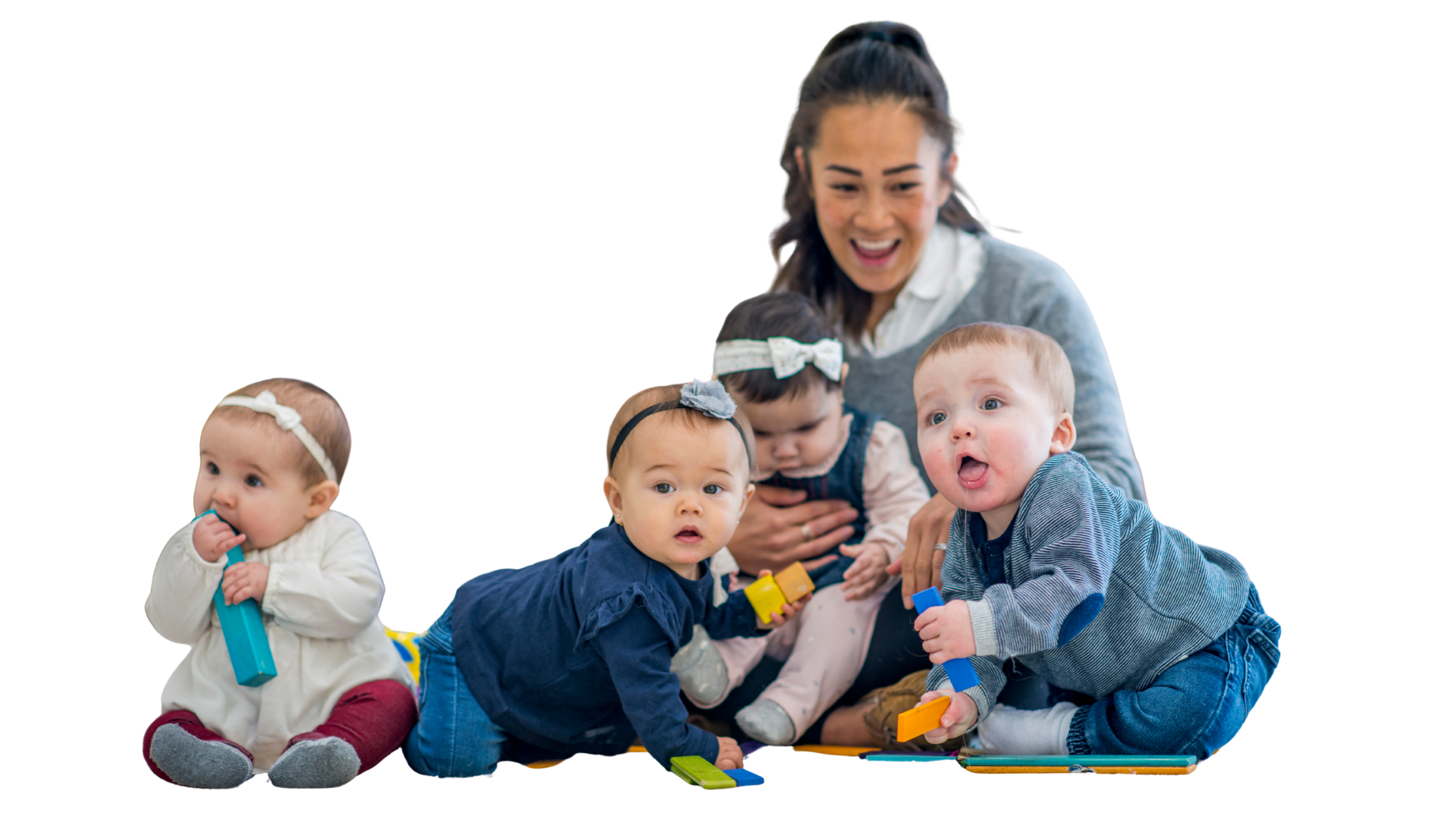 A woman playing with four babies on a colorful indoor play mat, engaging with blocks and toys, smiles and laughing.