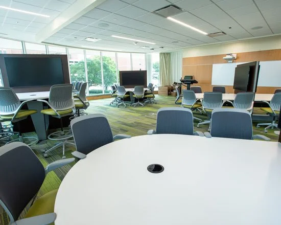 UAB School of Nursing collaborative classroom with round tables and wall-mounted displays