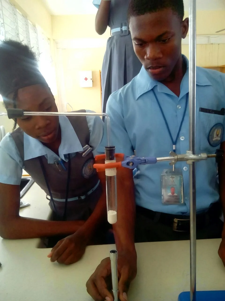 Students and teacher examining a robotic vehicle in a classroom