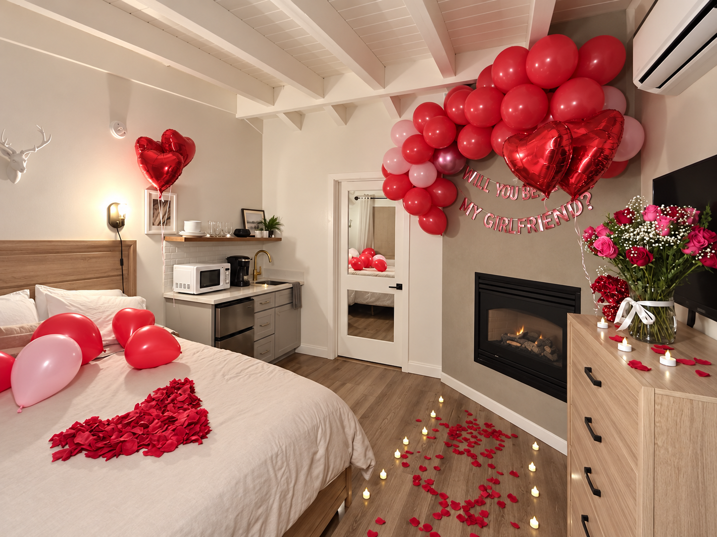 Romantic Tahoe room setup with red and pink balloons, rose petals, flowers and flameless candles