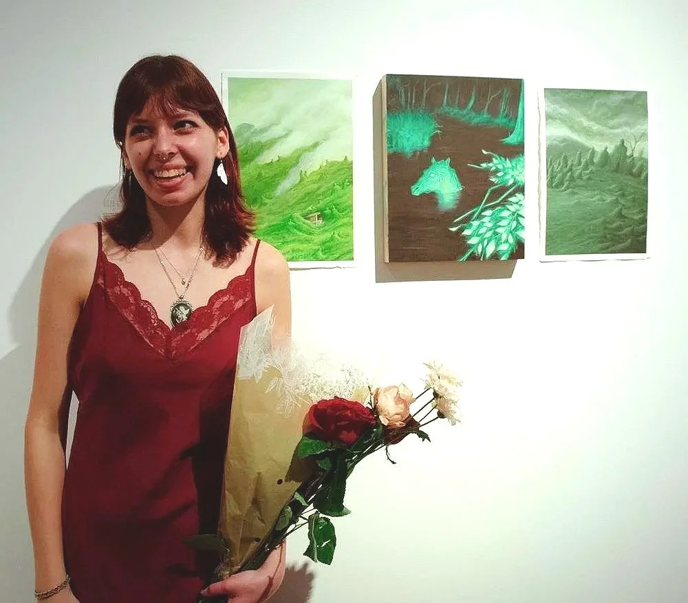 A woman in a red dress holding a bouquet of flowers at an art gallery.