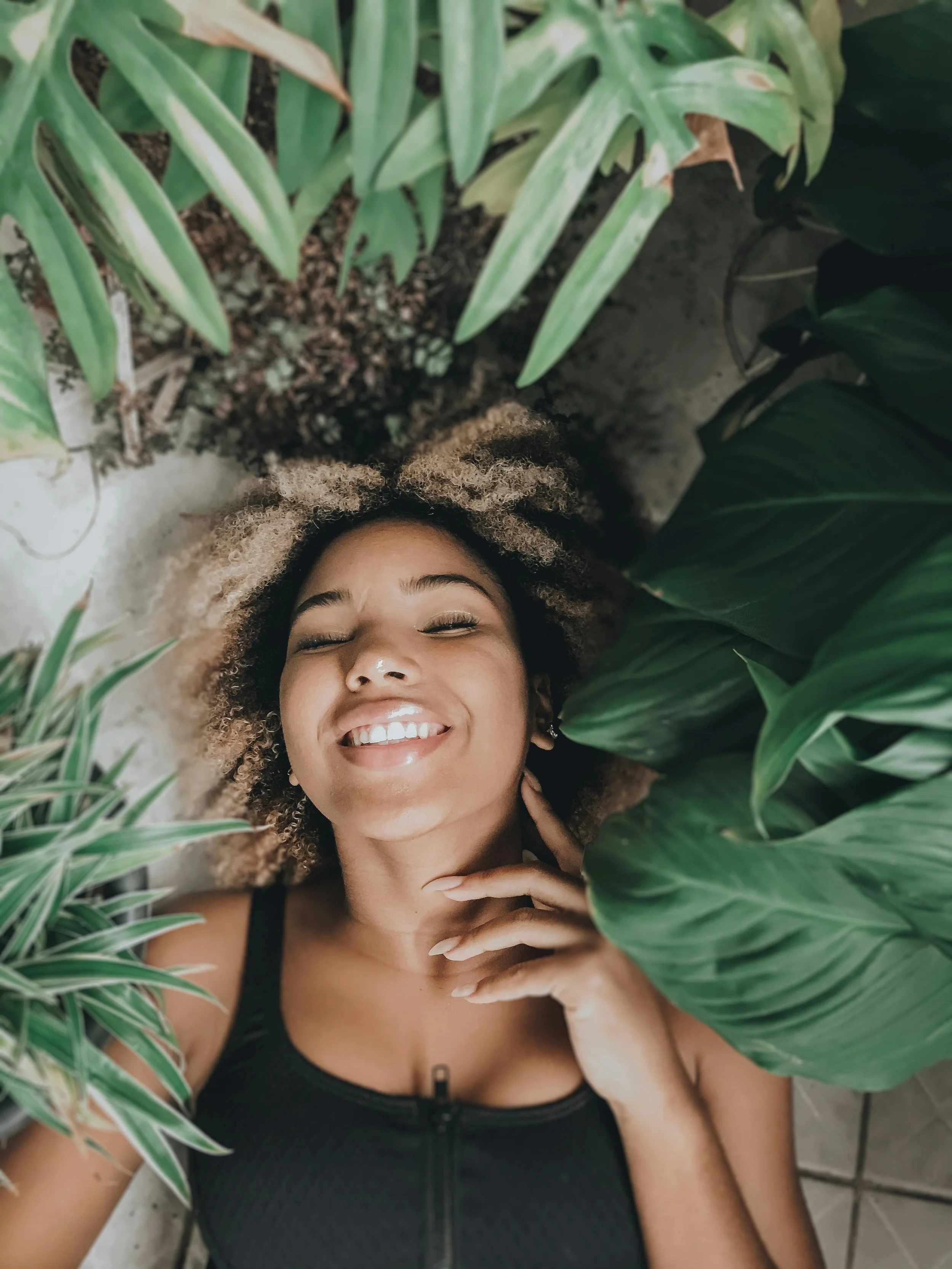 Young woman in a peaceful, joyful moment surrounded by greenery, representing the restored sense of self that follows teen therapy when the work fits
