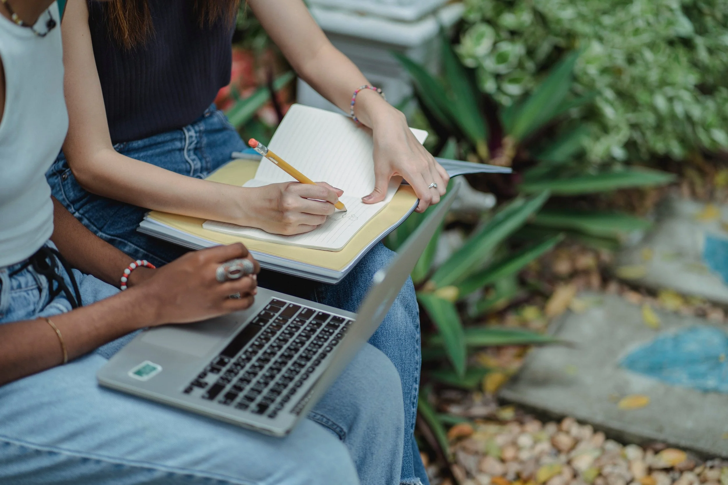 wo clinicians working together outdoors with a notebook and laptop, representing the supervision and consultation relationships at Healthy Mind, Healthy Heart in Atlanta
