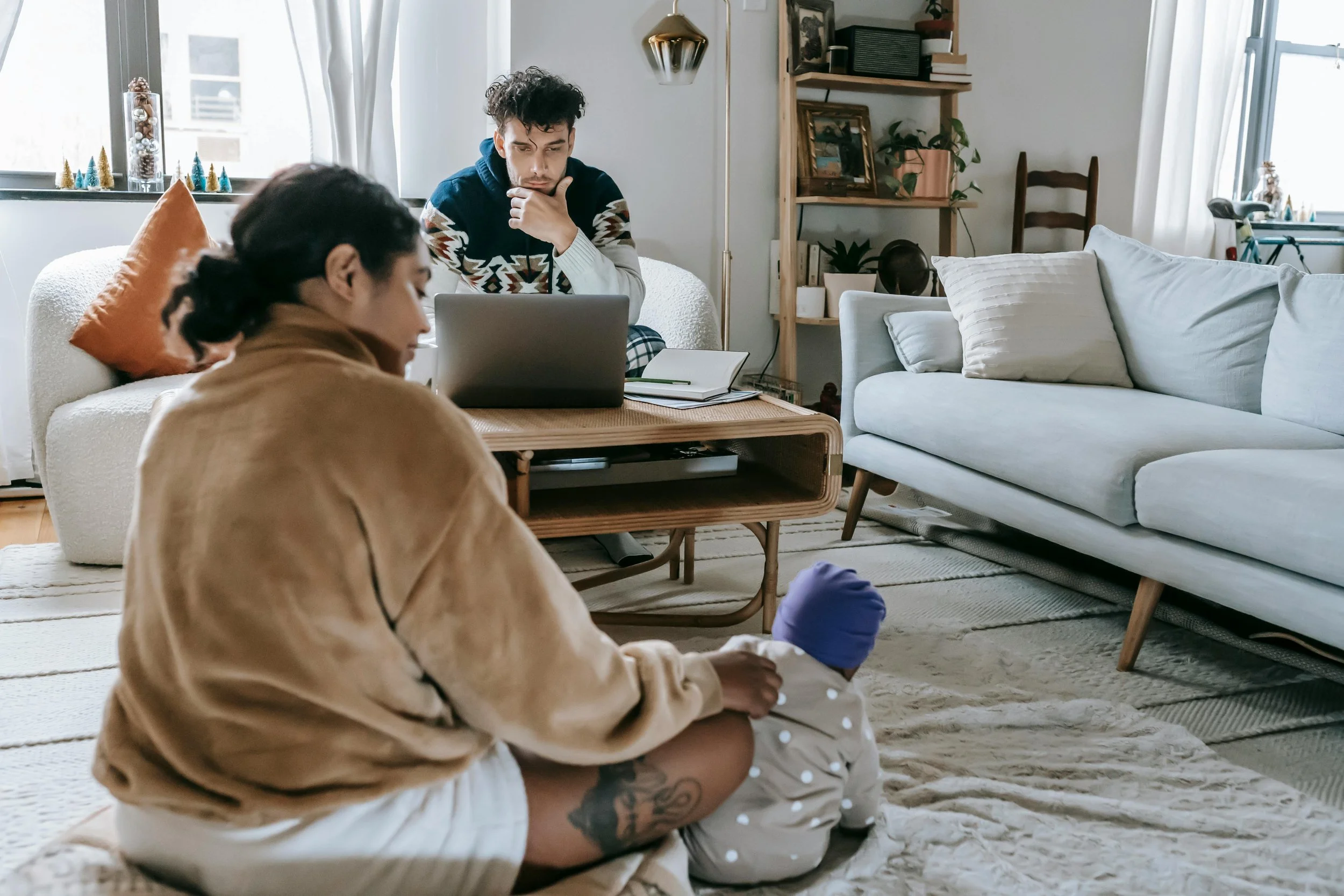 Parent at home with child in background, representing burnout therapy for adults carrying invisible labor in Atlanta, Florida, and Virginia