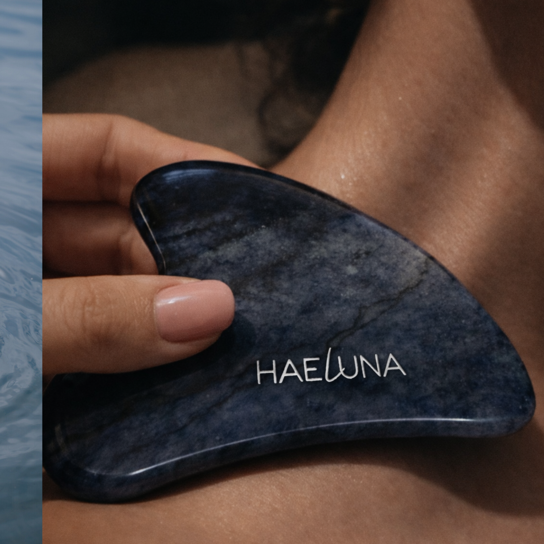 A hand holds a blue stone gua sha tool labeled "HAELUNA" and presses it against a person's neck.