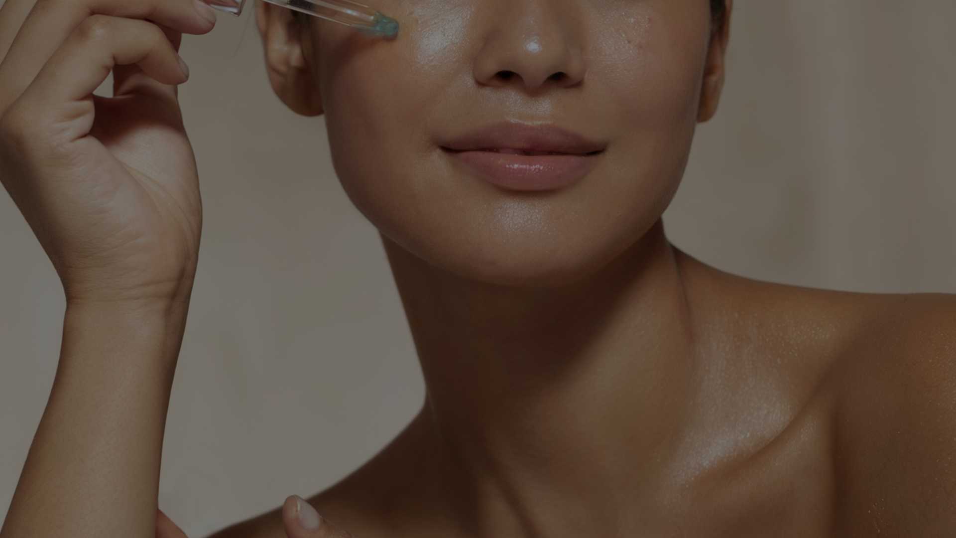 Person applying Blue tansy facial oil to cheek with a dropper, close-up of lower face, neck, and shoulders visible.