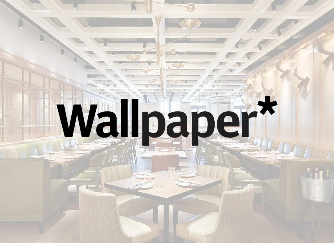 Elegant restaurant interior with white chairs, tables set with napkins and glasses, decorative lighting, and wall art with sculptures of birds.