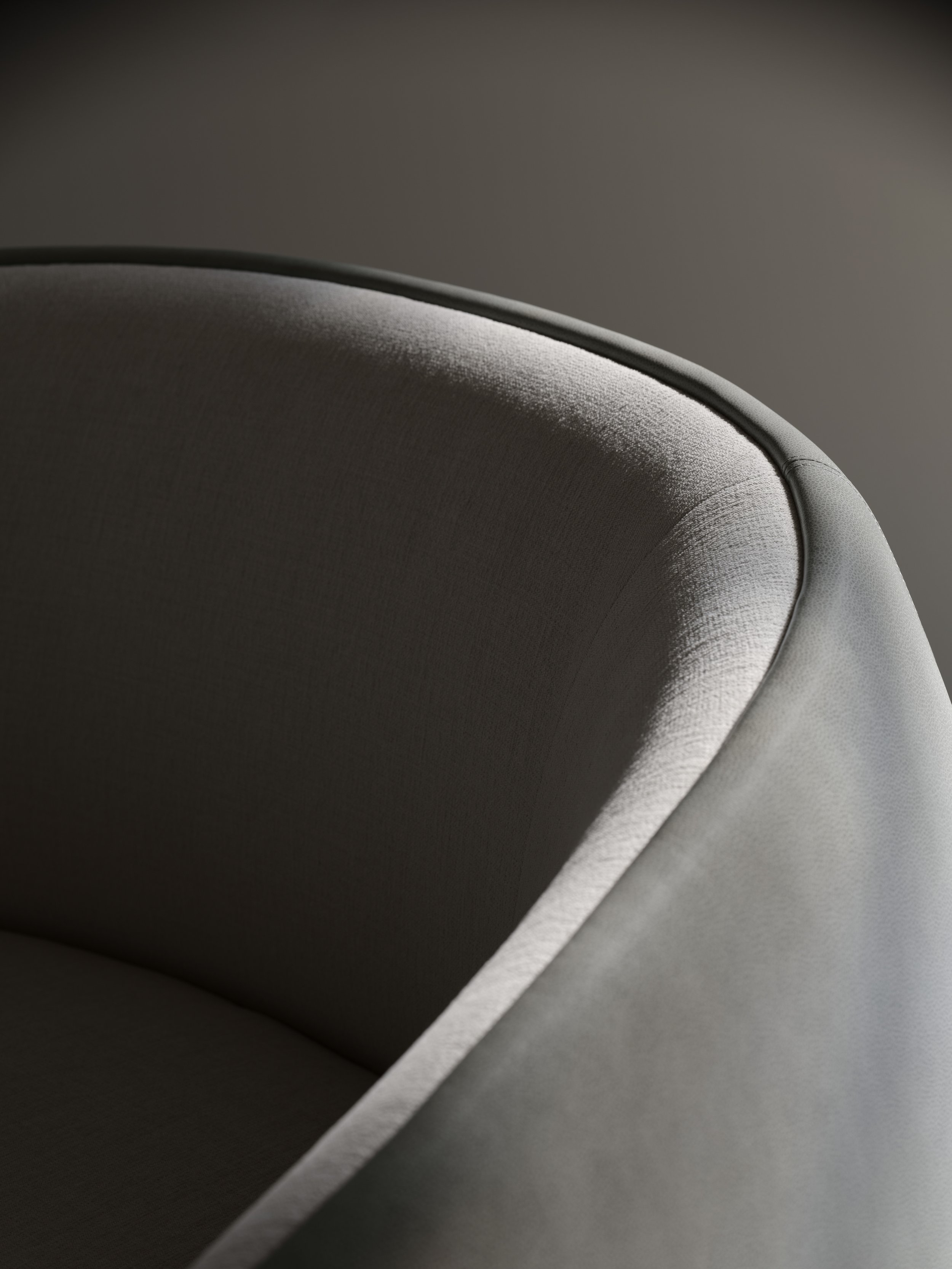 Close-up of a modern, upholstered armchair with light-colored fabric and curved backrest.