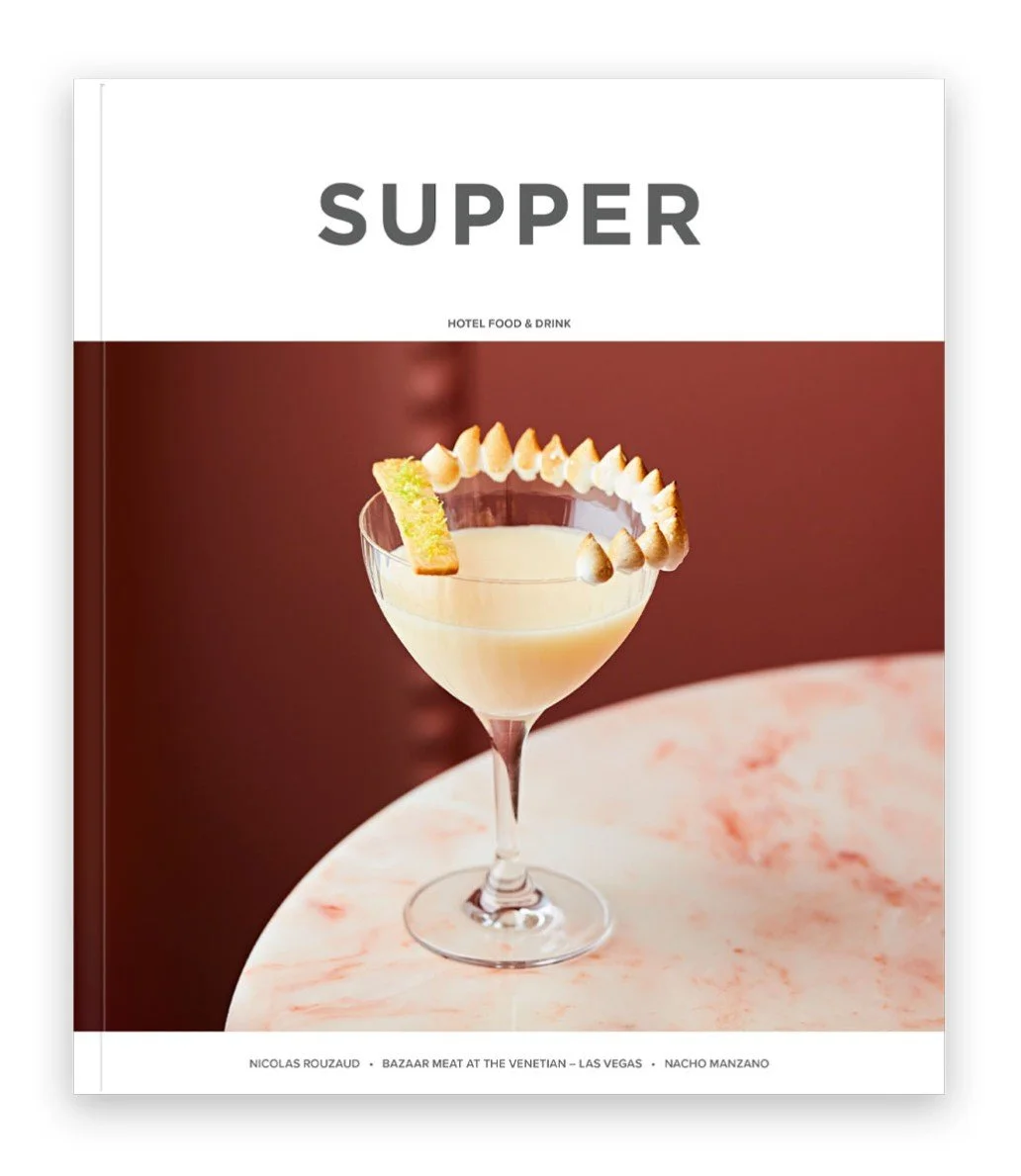 Cover of a menu or magazine titled 'SUPPER' with a cocktail drink garnished with lemon and meringue on a pink marble table.