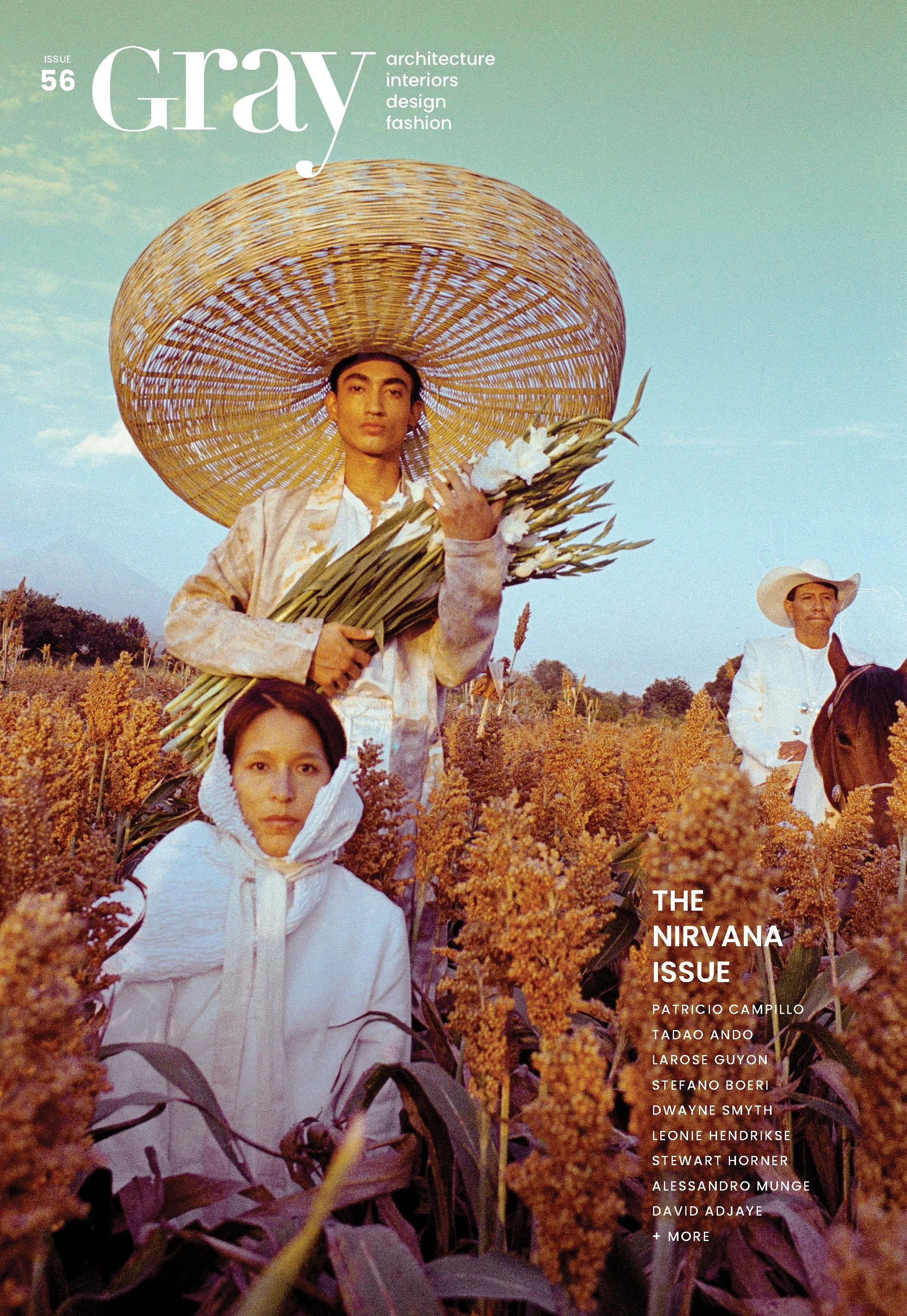 A magazine cover titled "Gray" issue 56, featuring a young person holding a bouquet of white flowers, wearing a large wide-brimmed straw hat, standing in a field of tall, orange-brown plants, with a blue sky background.
