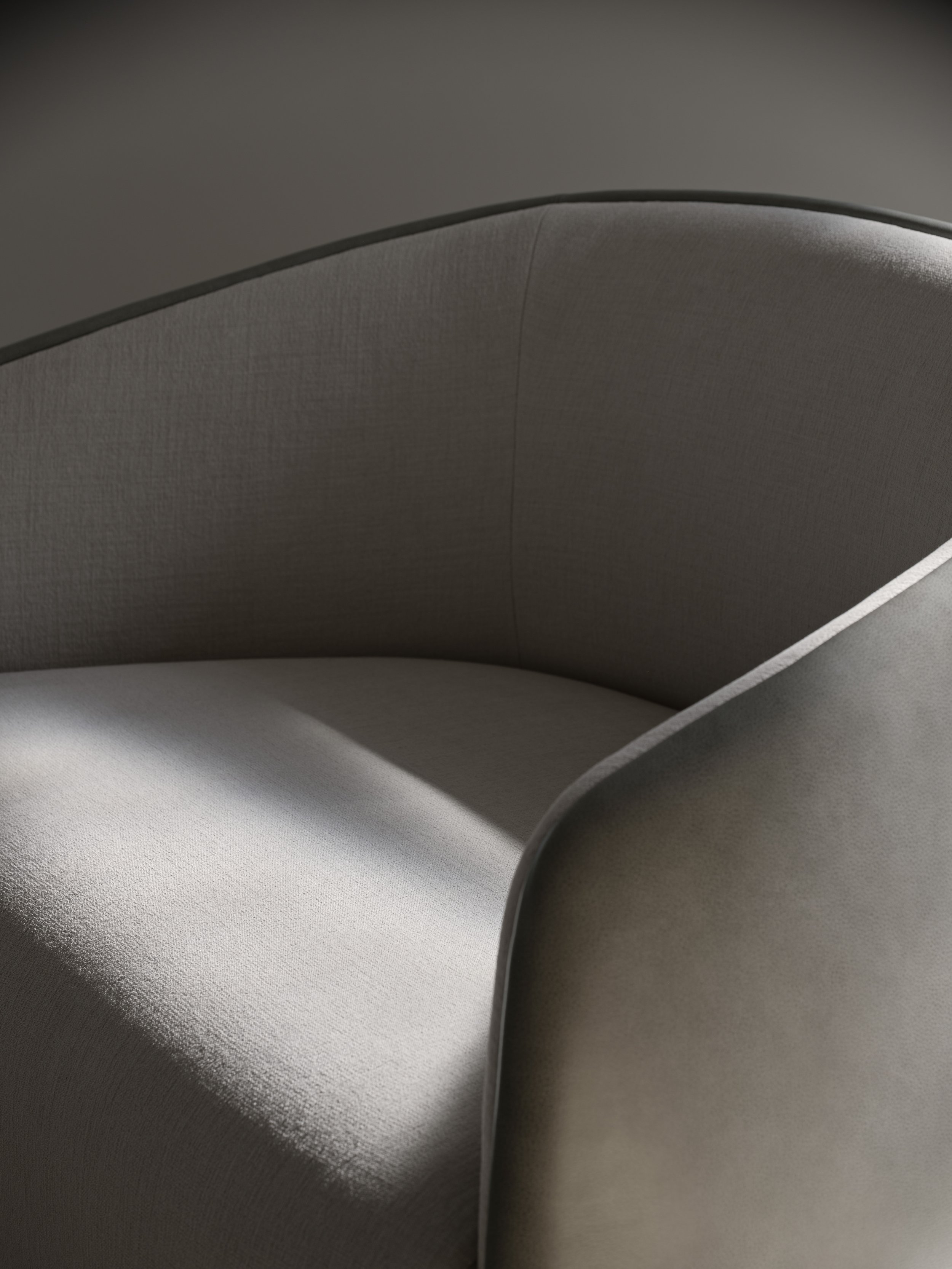 Close-up of a curved, light-colored fabric upholstery with a dark edge and shadowed background.