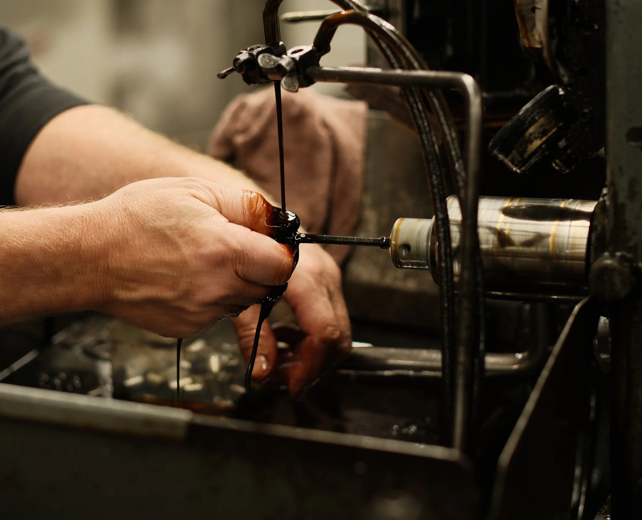 carbide tooling solutions.- A person's hands working with machinery, possibly performing mechanical or industrial work, with machines and tools in the background.