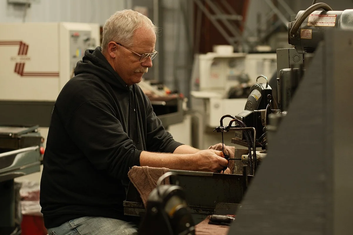 A man working on a piece of machinery in a workshop.