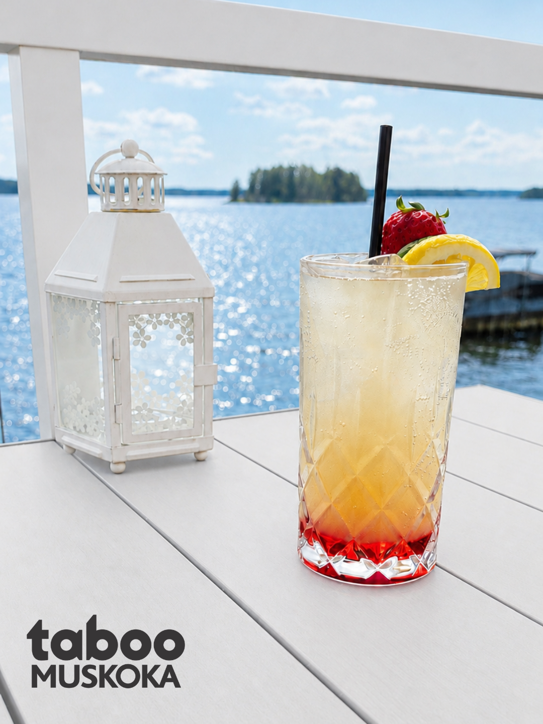 Pink Paradise cocktail with strawberry and lemon garnish on a lakeside table overlooking Lake Muskoka at The Boathouse at Taboo