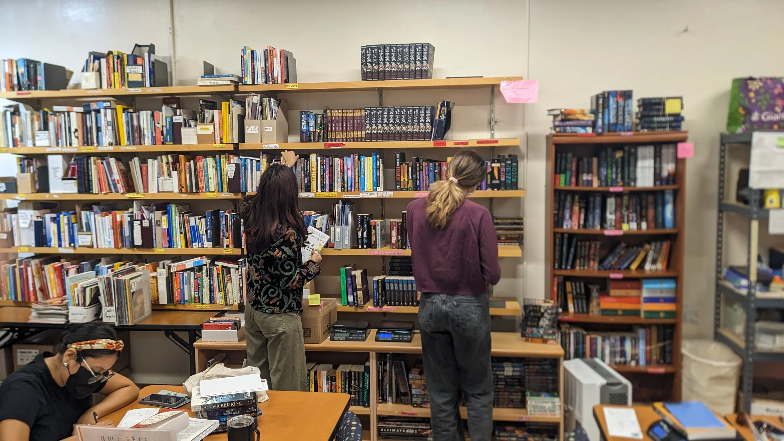 Volunteers picking books off the bookshelves.