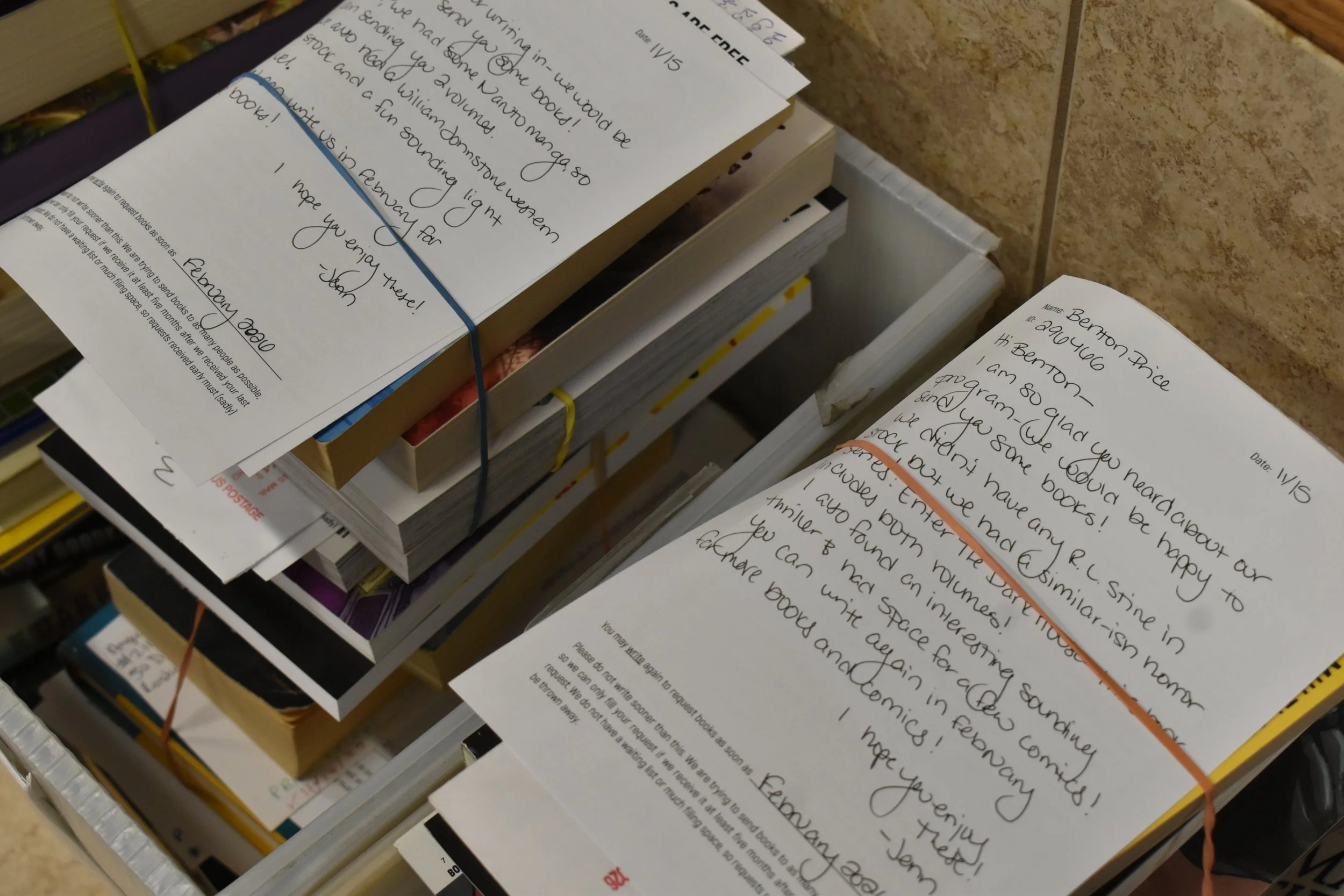 Books being donated to prisons with attached letters