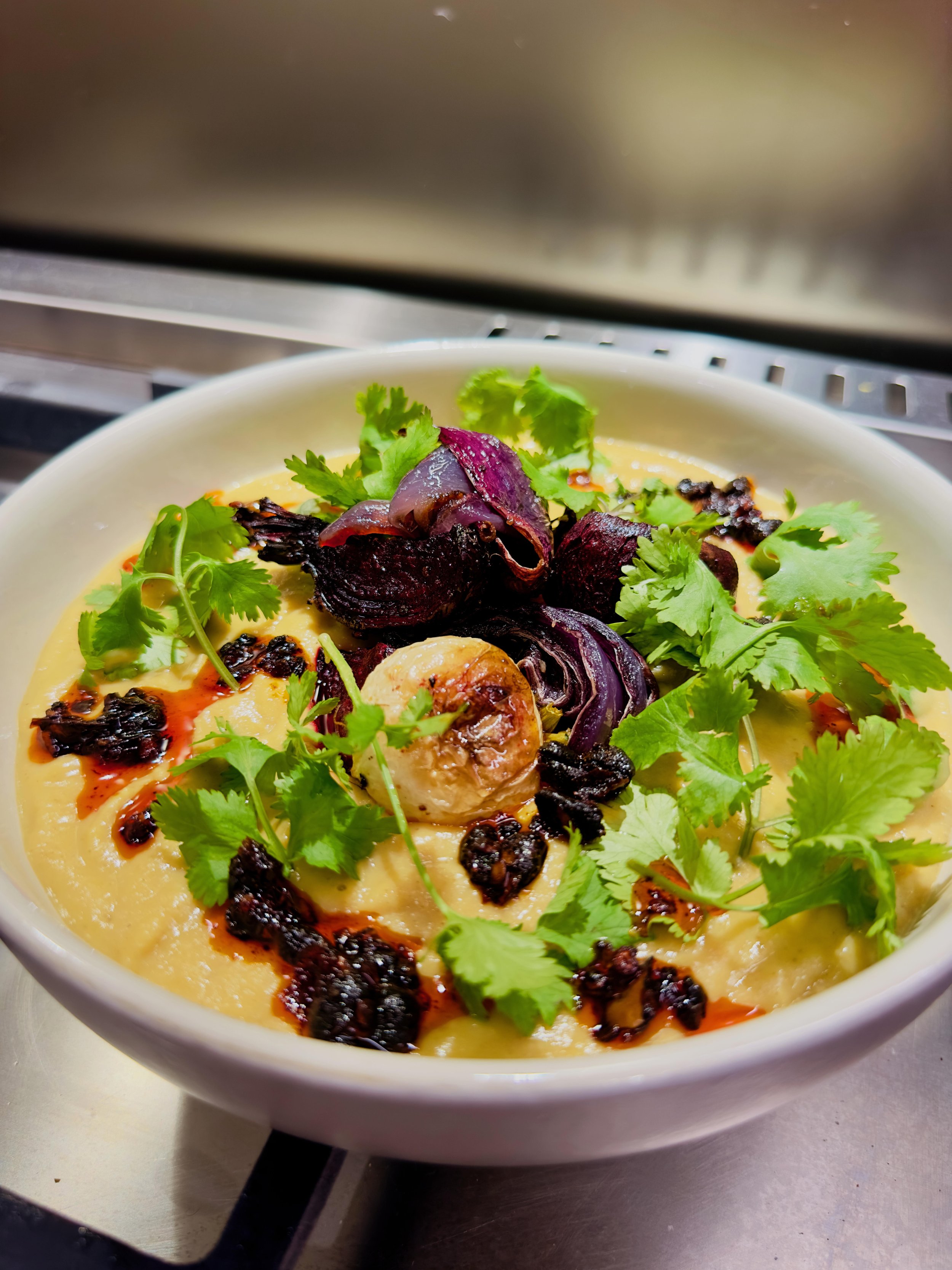 Hot roast vegetable soup topped with crisp vinegar beet salad and cilantro - home cooking and food photography by Matt Kollander
