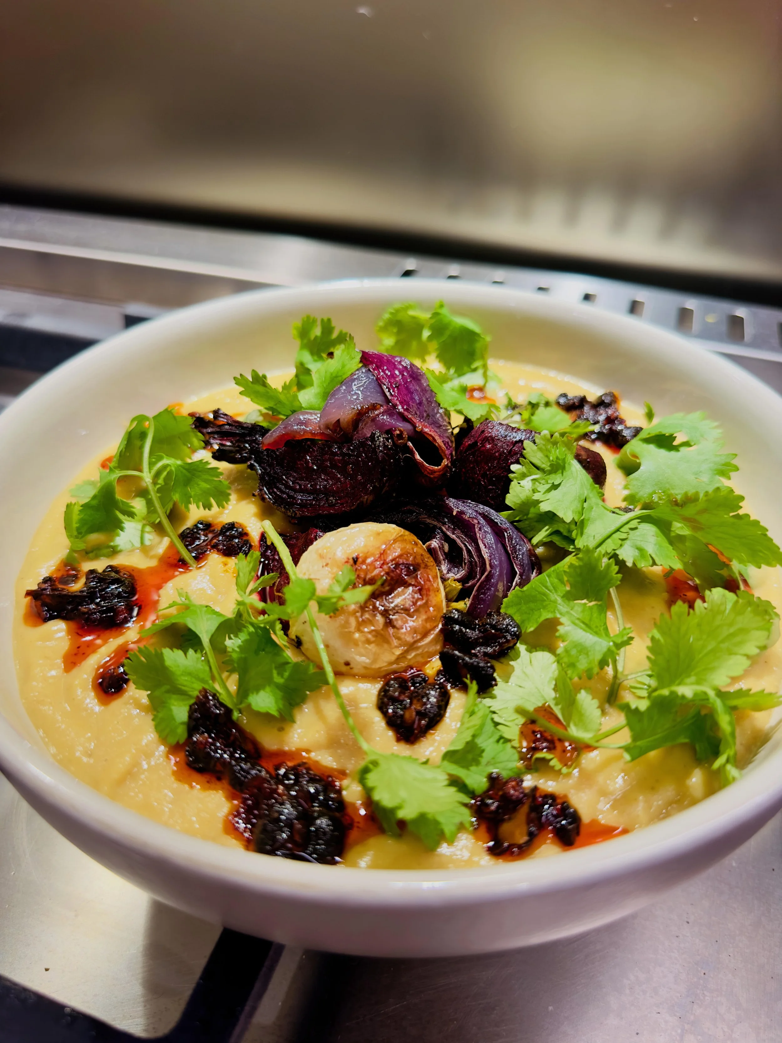 Hot roast vegetable soup topped with crisp vinegar beet salad and cilantro - home cooking and food photography by Matt Kollander