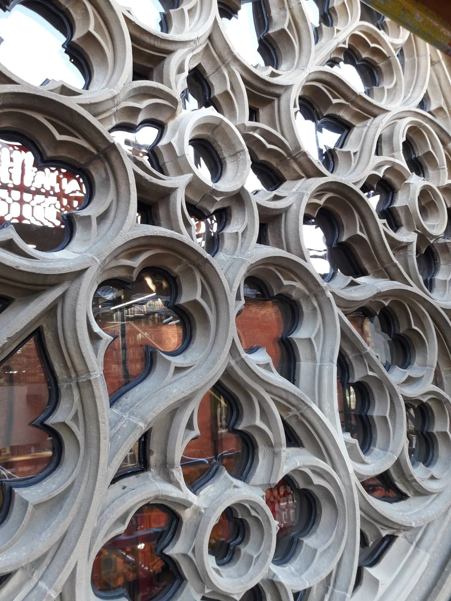 Close-up of a decorative architectural facade with carved stone designs and glass windows.
