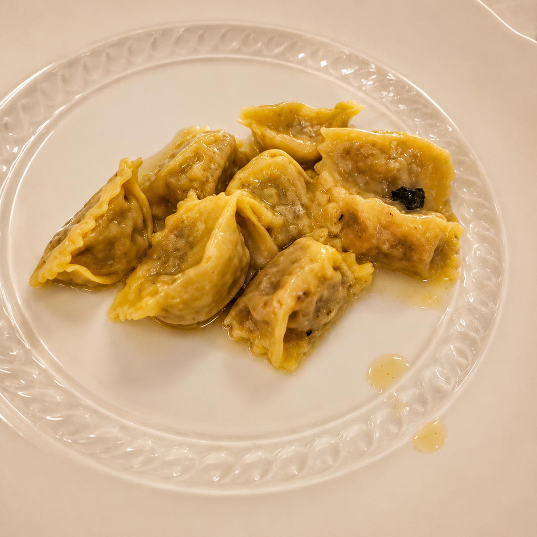 Tender braised oxtail agnolotti served in nutty brown butter and finished with fresh herbs and aged cheese.