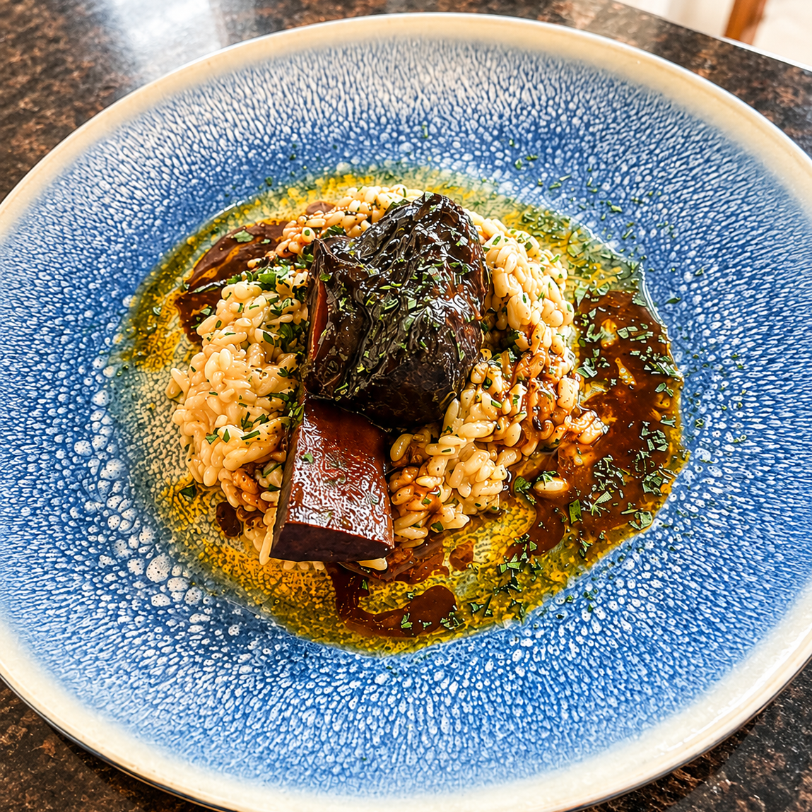 Tender braised short rib with creamy coconut parmesan risotto and a velvety jus reduction. 