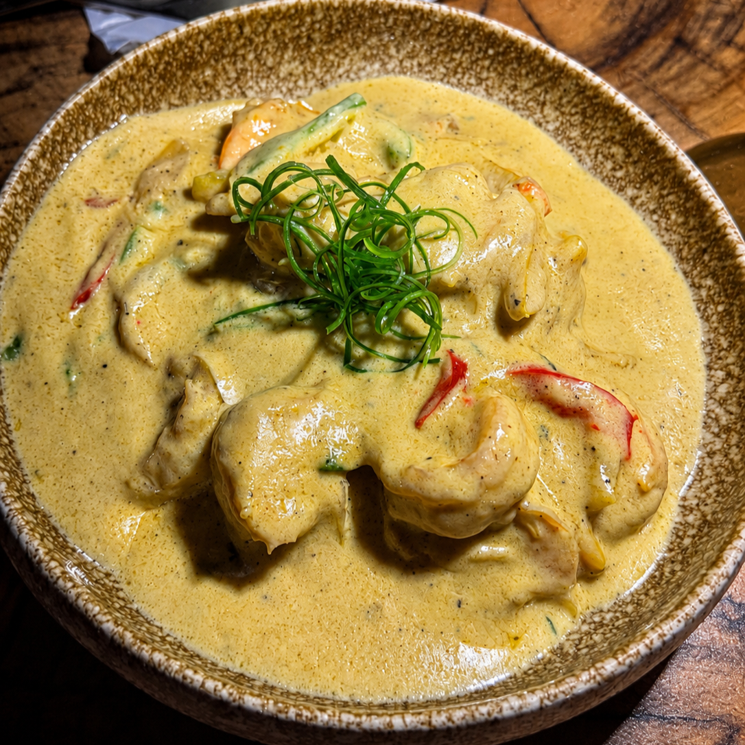 Poached shrimp in a silky coconut curry velouté with crispy cassava and delicate finished herbs. 