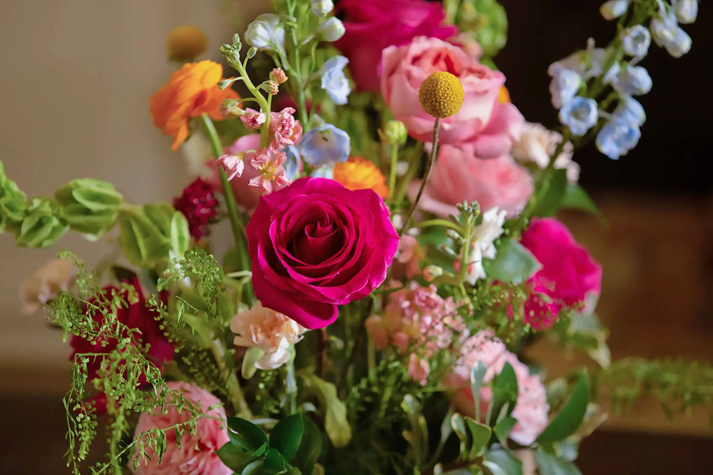 Lively bouquet of pinks, orange, yellow, and blue flowers for wedding in central Louisiana.