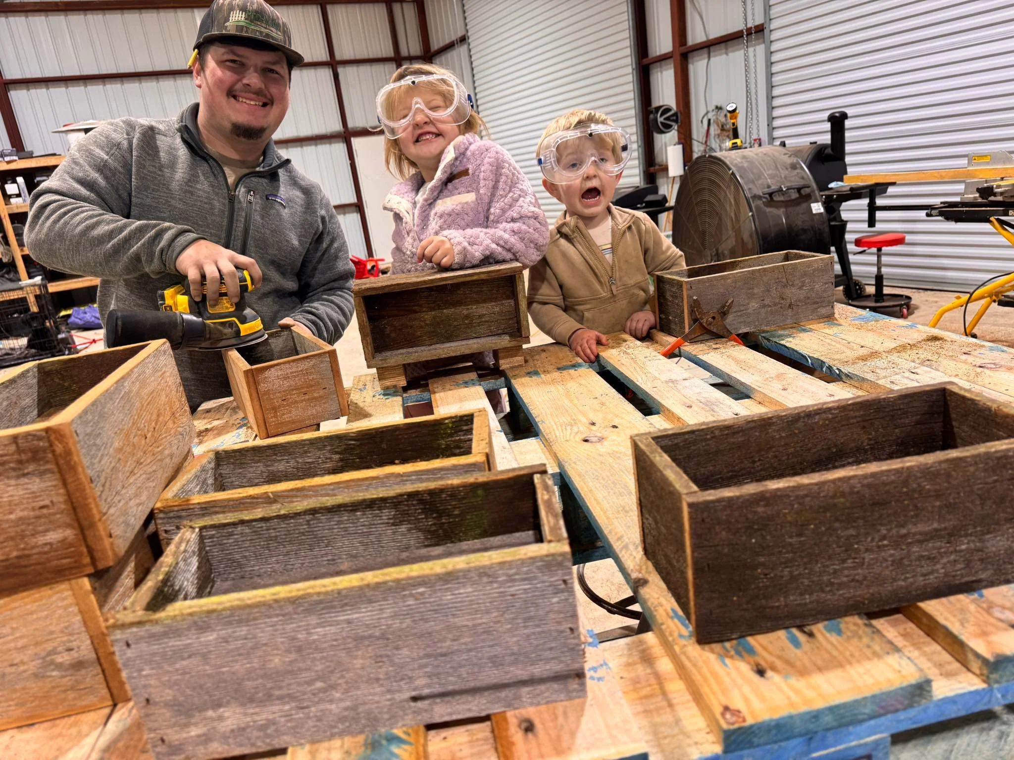 Dad and kids sanding boxes at Central Louisiana florist shop.