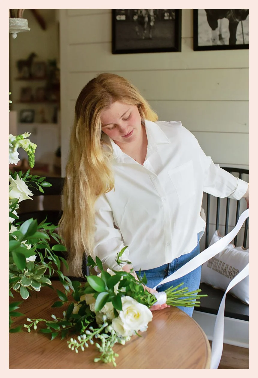 Local florist in Alexandria, LA tying a fresh bouquet with ribbon.