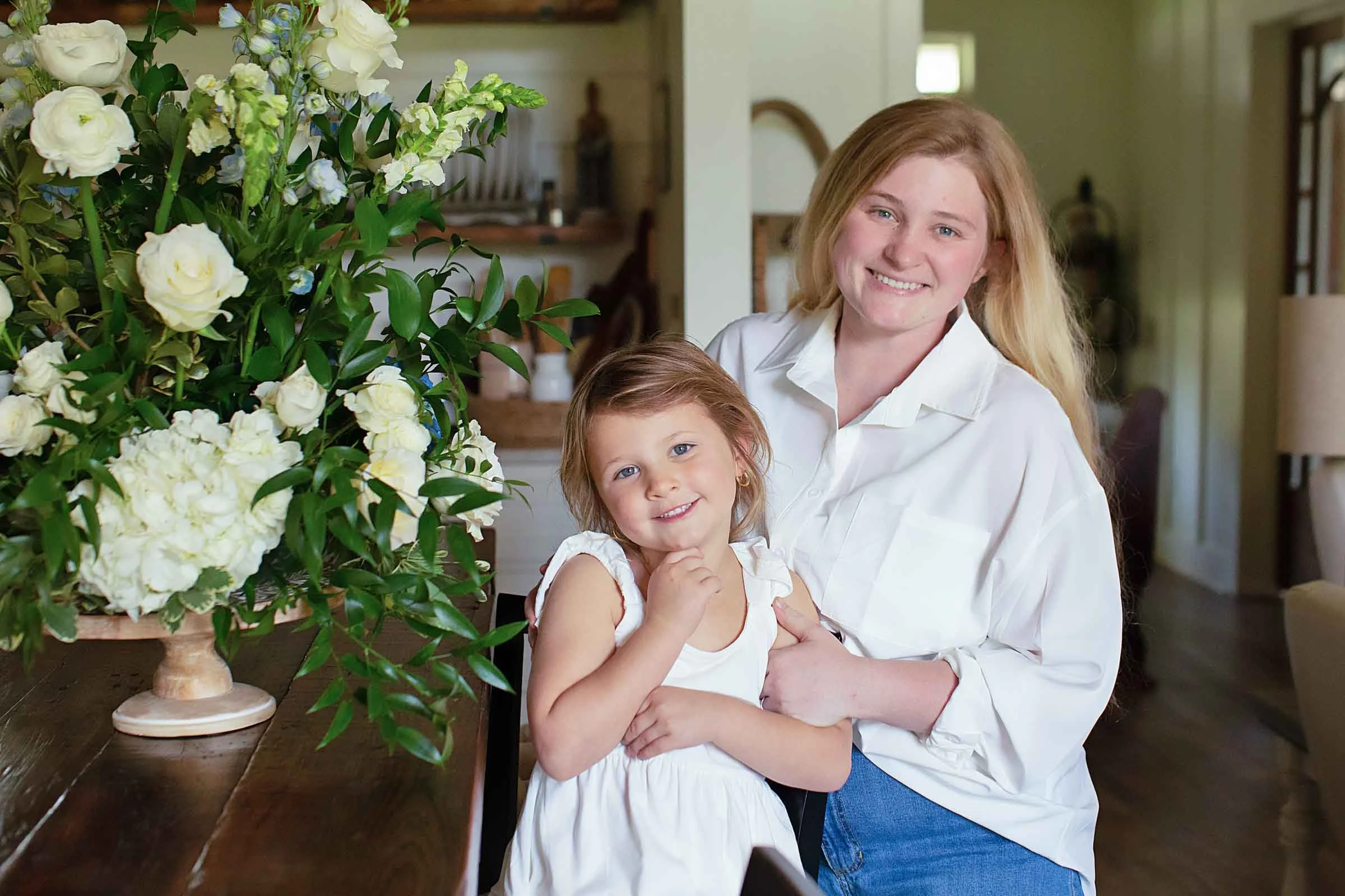 Central Louisiana florist with her daughter next to a flower arrangement.