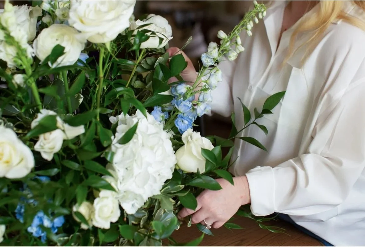 A beautiful white and blue bouquet being made by a florist in Alexandria, Louisiana.