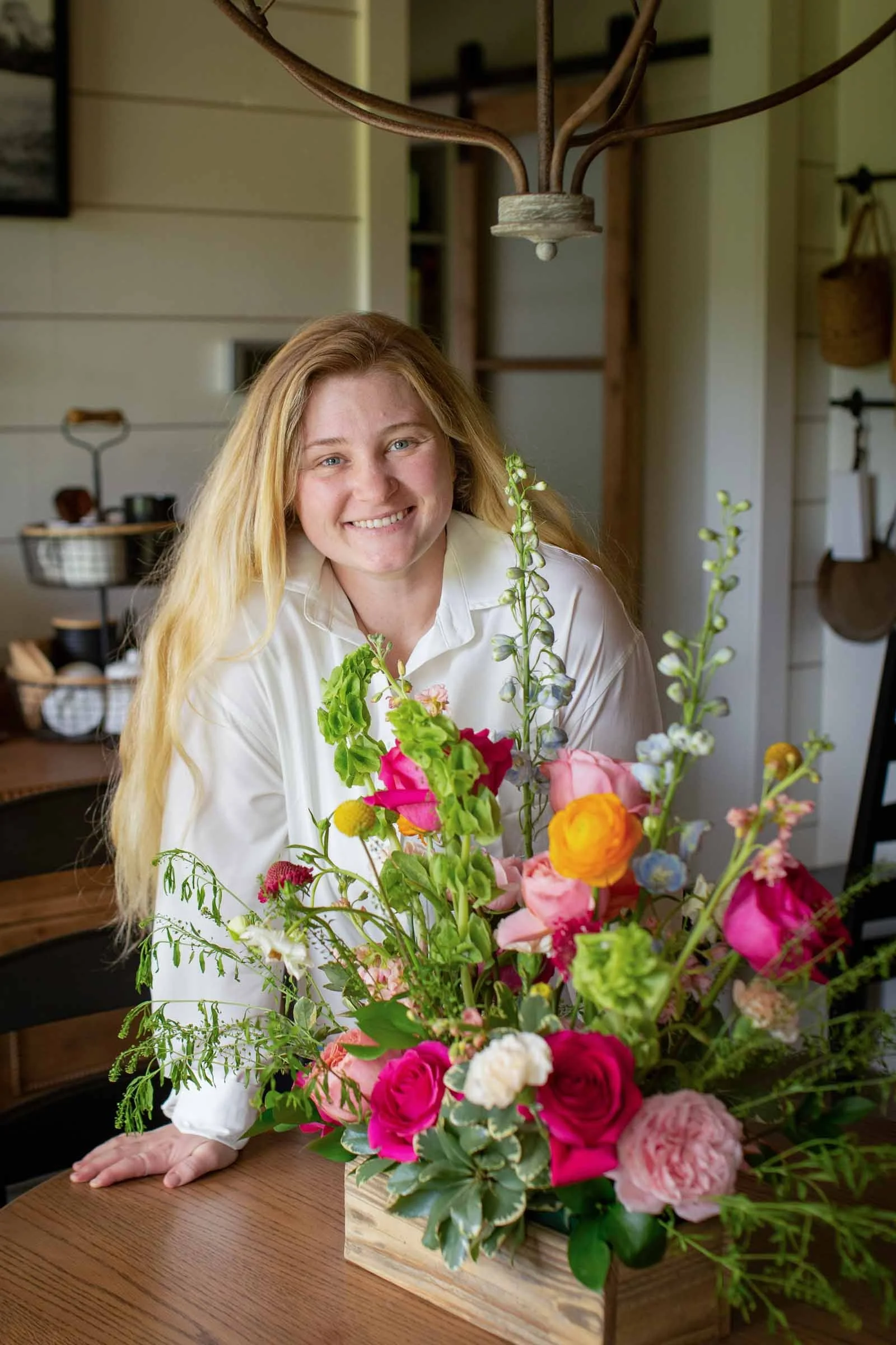 A central Louisiana florist at a table with a colorful wedding arrangement.