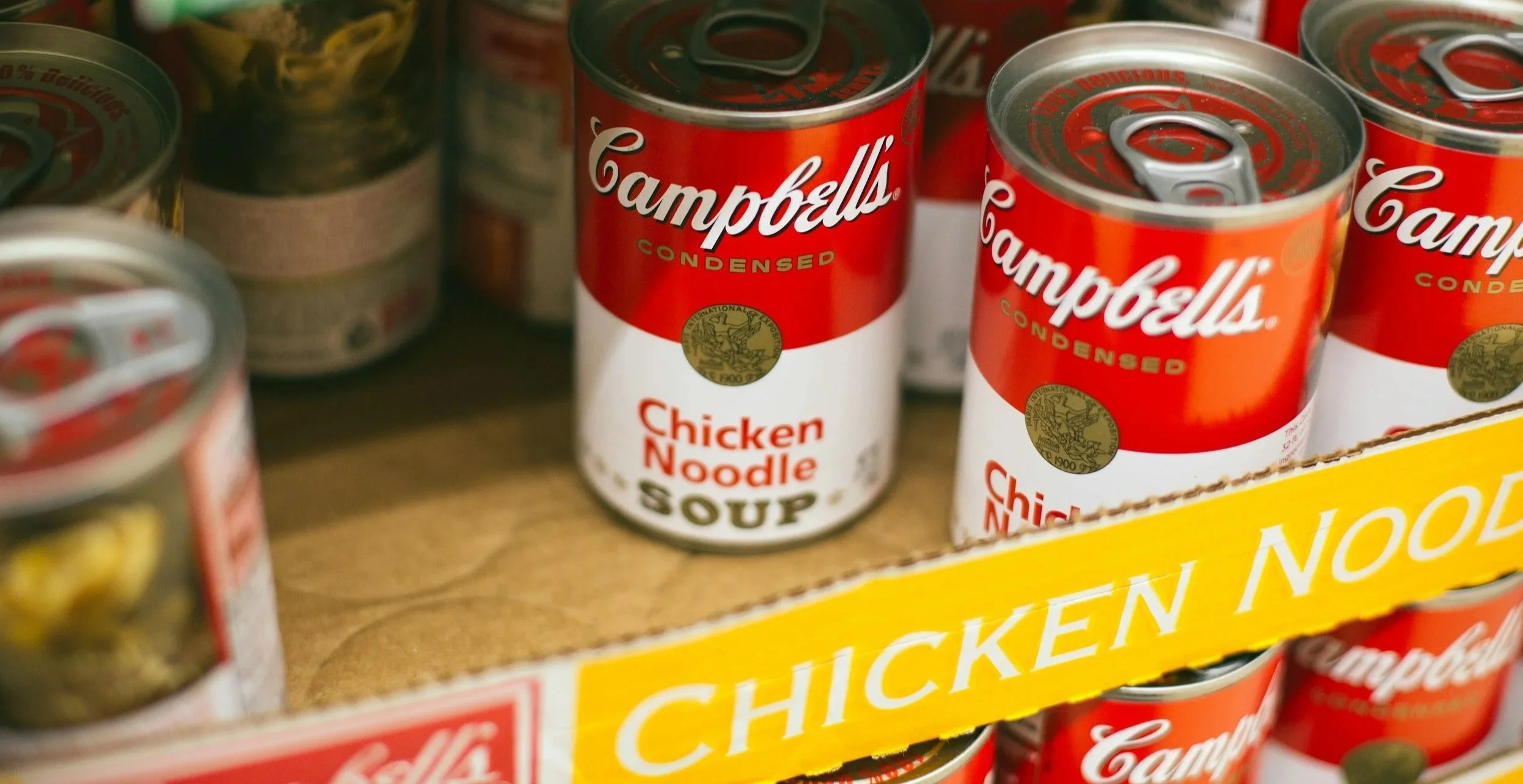 Can canned Campbell's condensed chicken noodle soup on store shelf.