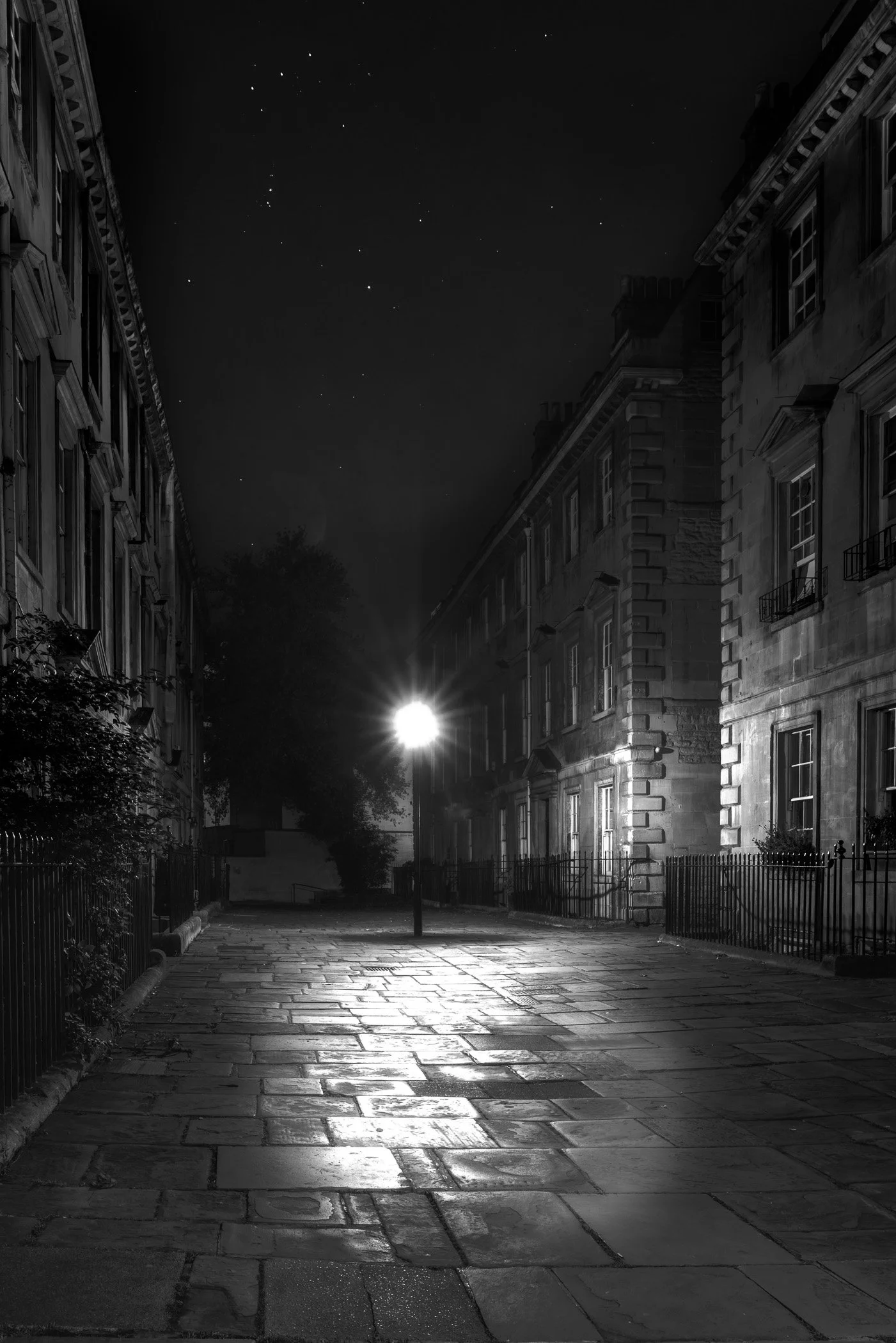 Lamp at Night A moody, close-up night photograph highlighting an ornate Victorian street lamp against historic stonework.