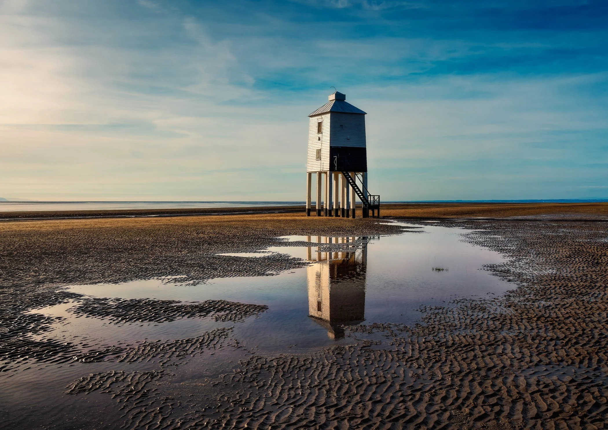 Sentinel at Low Tide A serene daytime perspective highlighting the unique architectural stilt design of Burnham-on-Sea's coastal landmark.