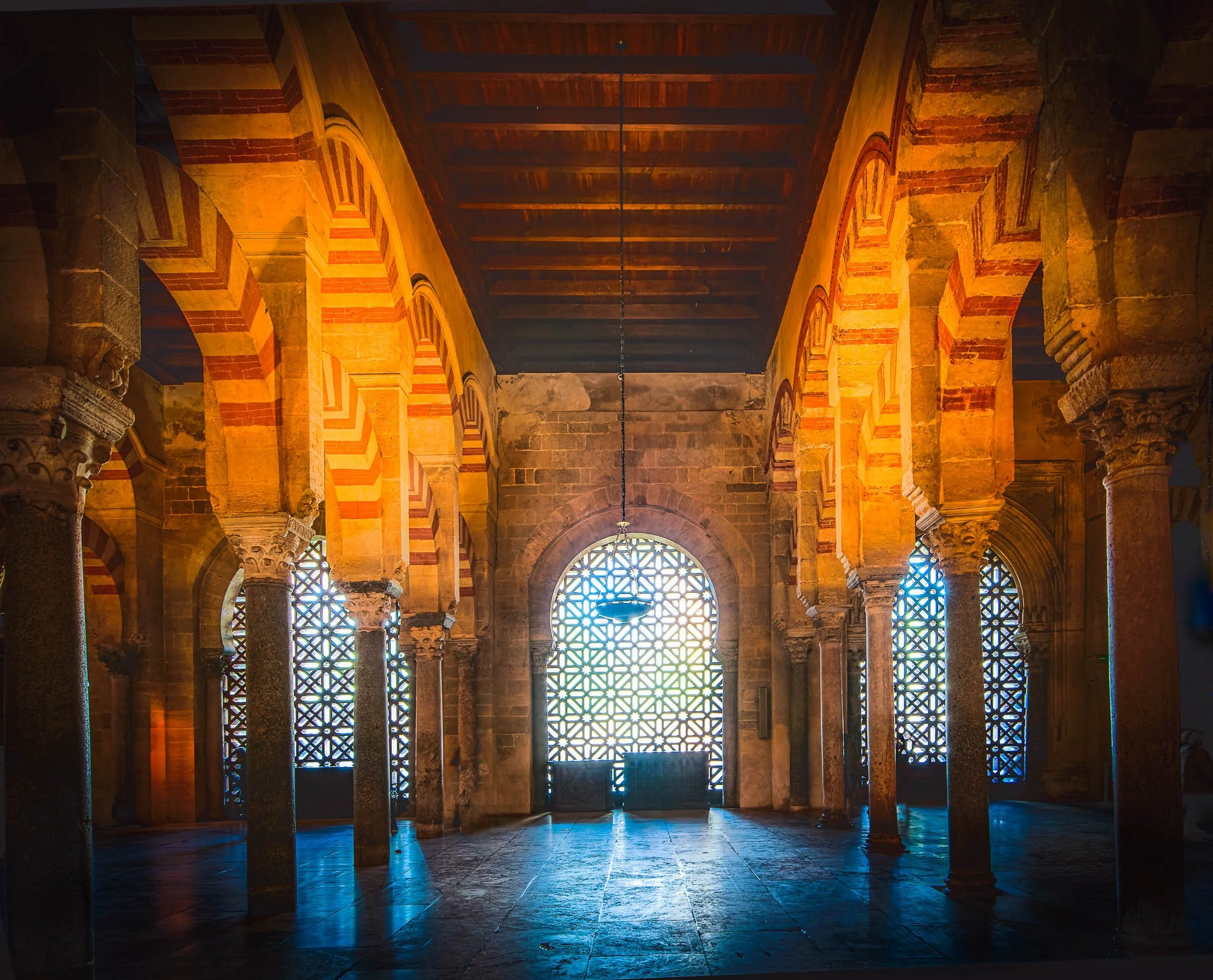 Sacred Geometry of Light Soft sunlight streaming through the intricate lattice windows of the Mezquita.