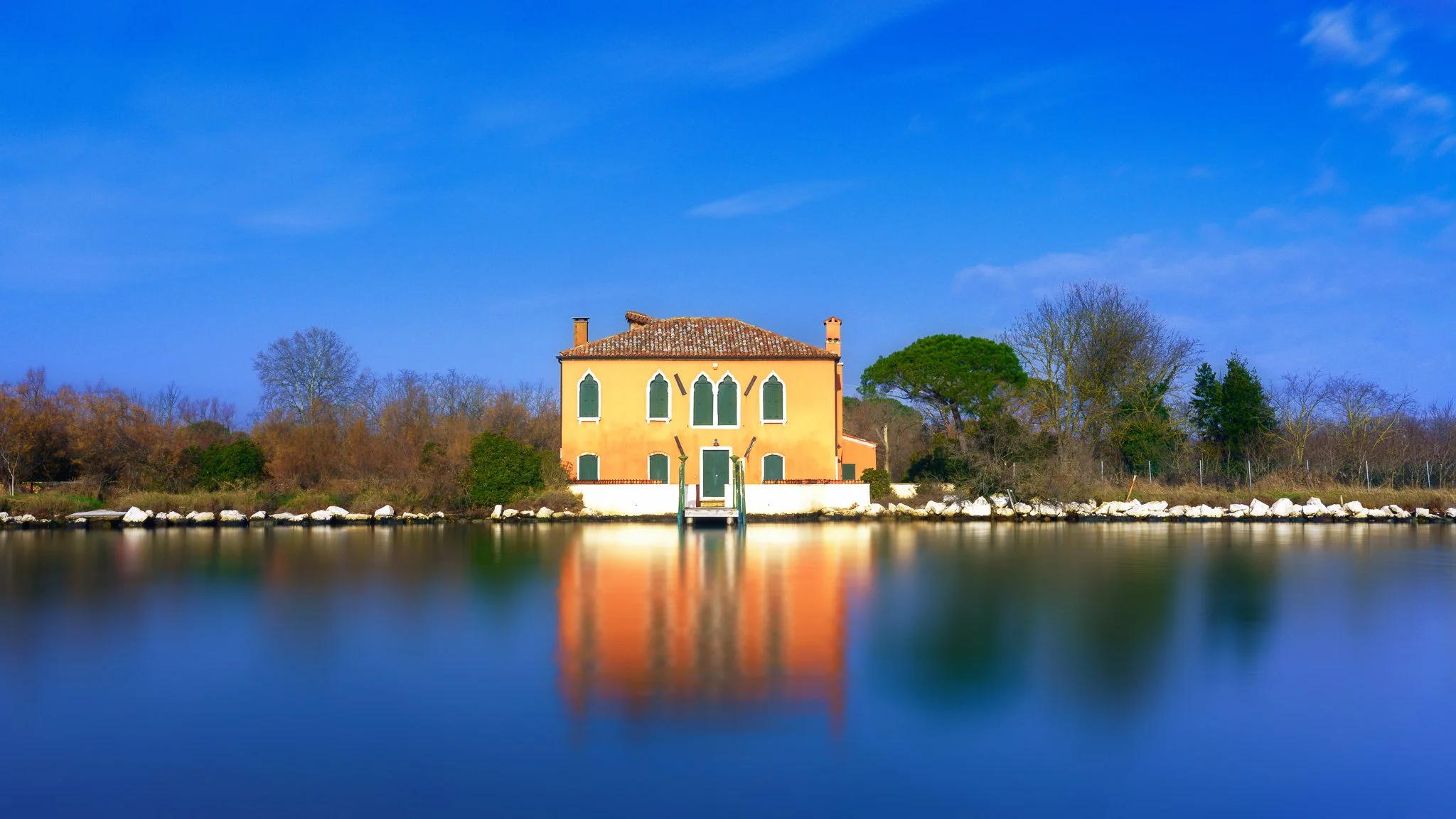 A solitary house near Burano reflected in the calm Venetian Lagoon, captured in a minimalist fine art composition of light, space, and stillness.