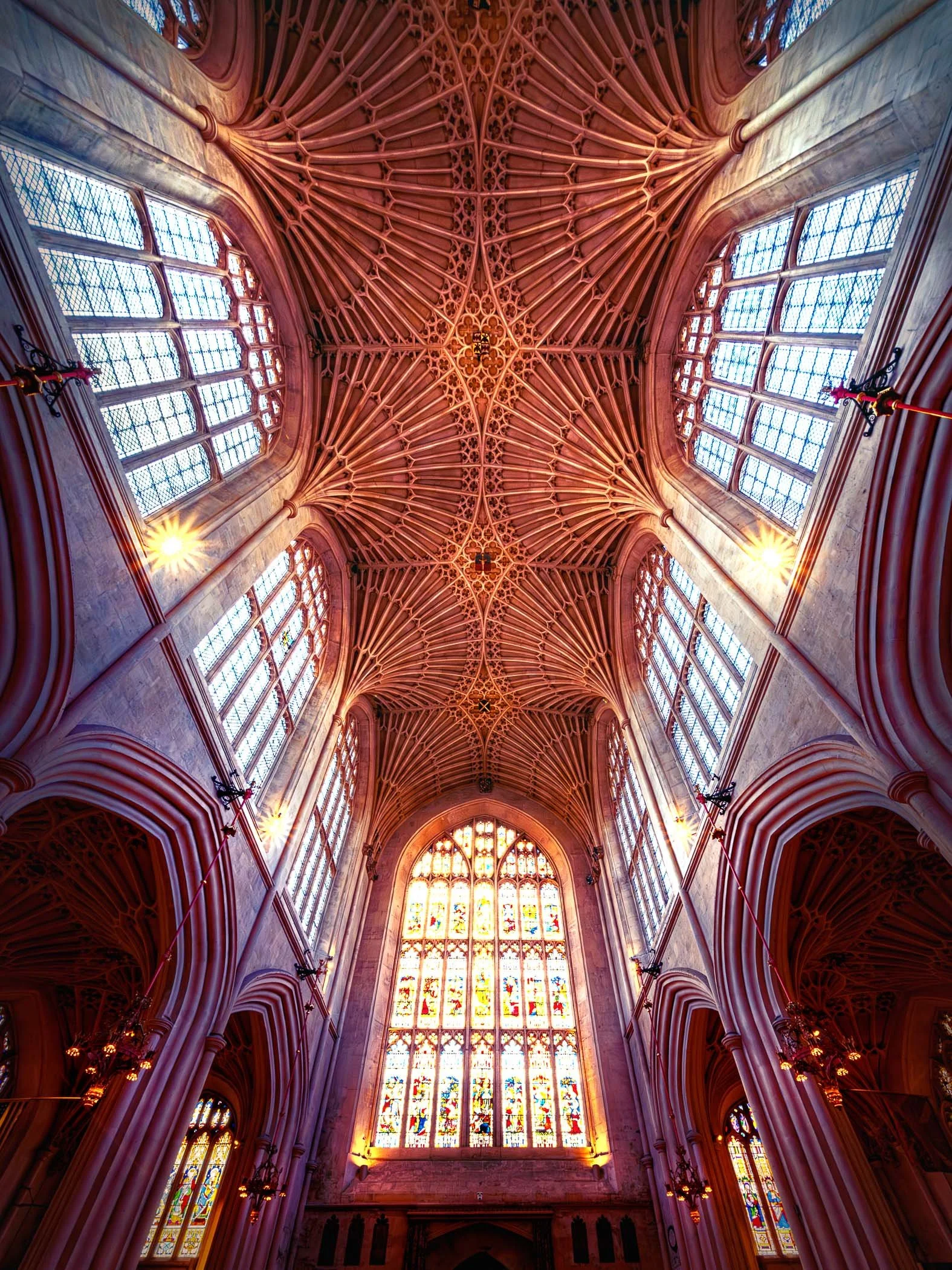 Heavenly Heights, The Fan Vaulting of Bath Abbey A direct upward view emphasizing the famous, detailed fan-vaulted ceiling inside Bath Abbey.