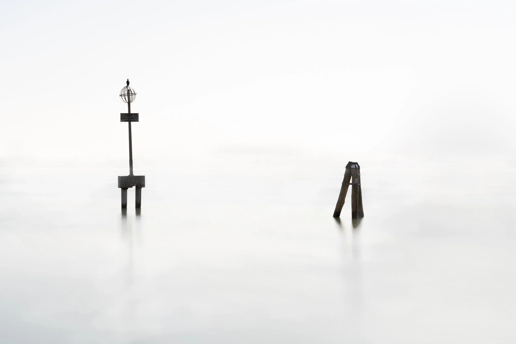 Venice Seascape Minimalist wooden pilings dotting the quiet Venetian horizon under a vast, soft sky.