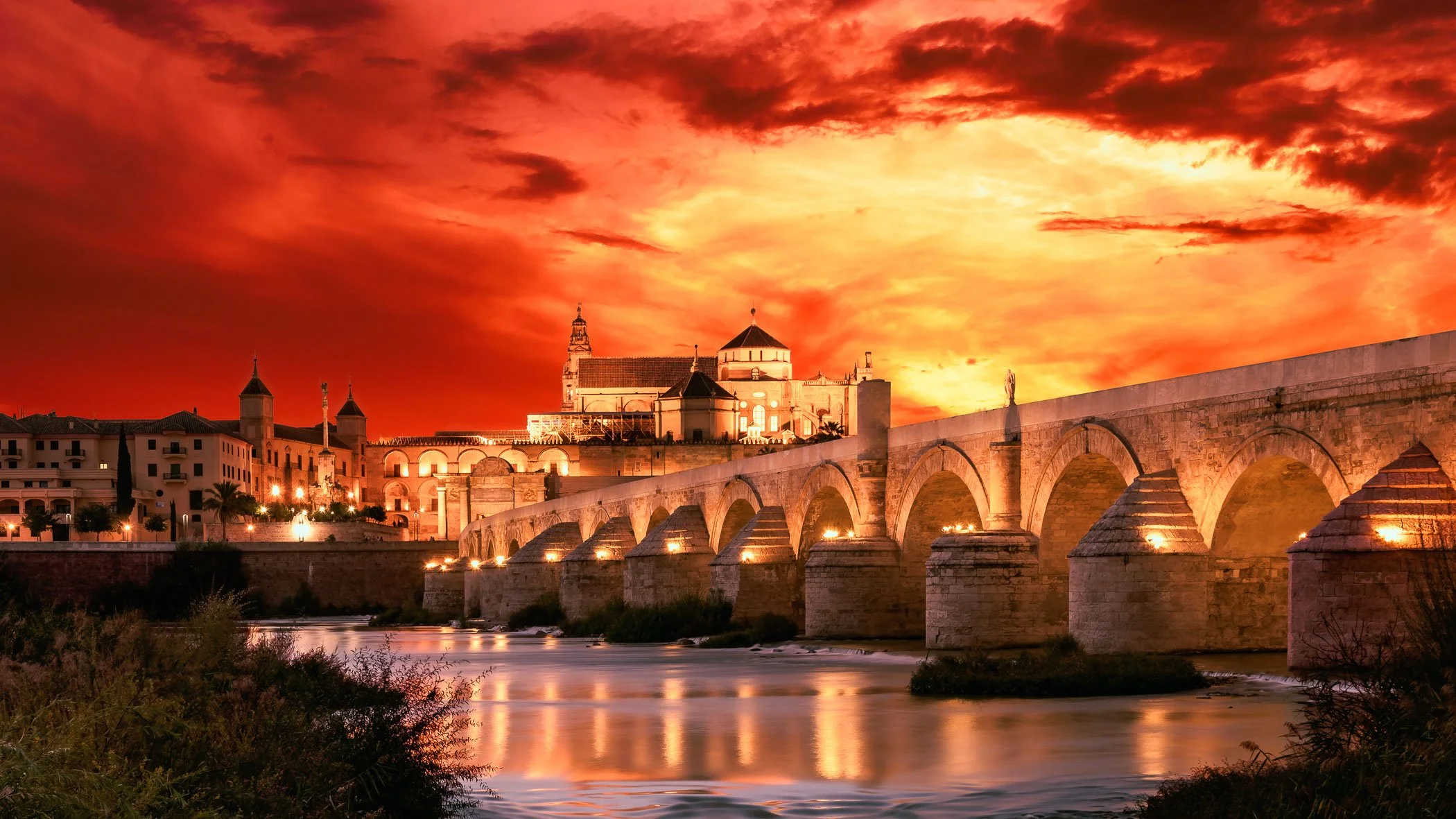 Cordoba Sunset Skyline Vibrant evening light casting dramatic crimson and golden hues across the ancient city.