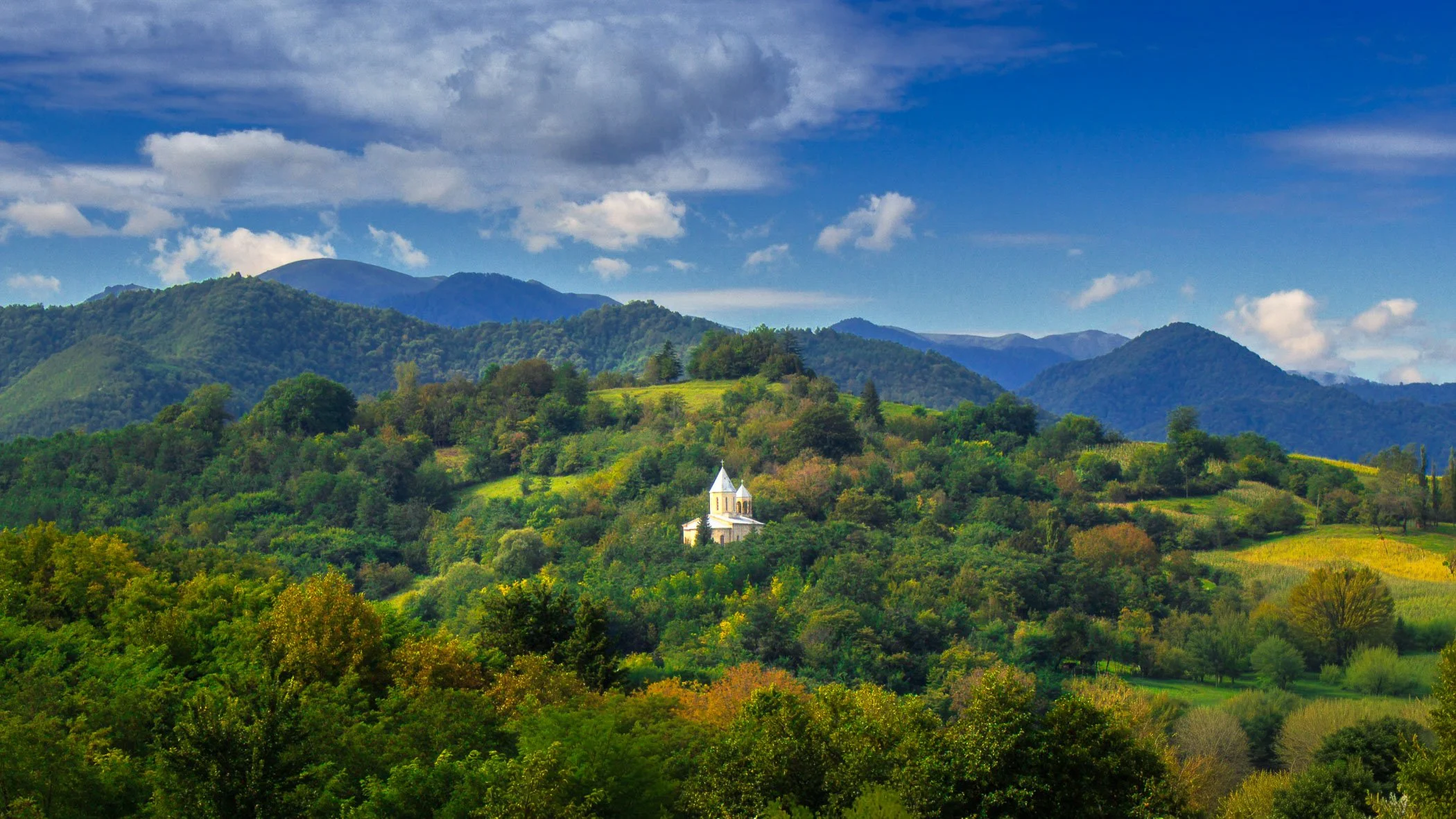 A Church at Obcha Historic countryside church architecture nestled peacefully among lush surrounding trees and foliage.