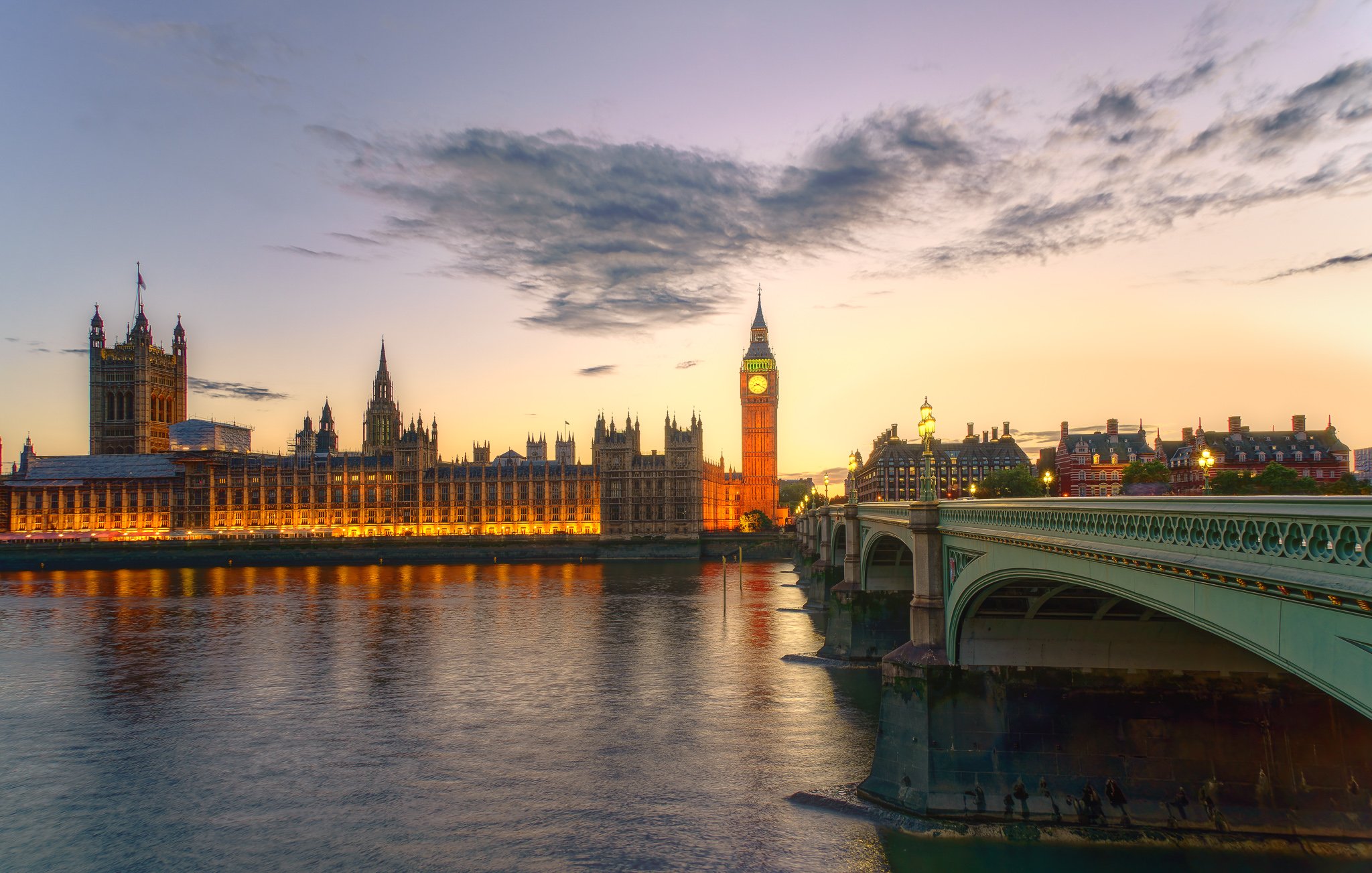 Fine art photograph of Big Ben and Westminster Bridge at sunset, with warm evening light, calm Thames reflections, and a classic London cityscape.