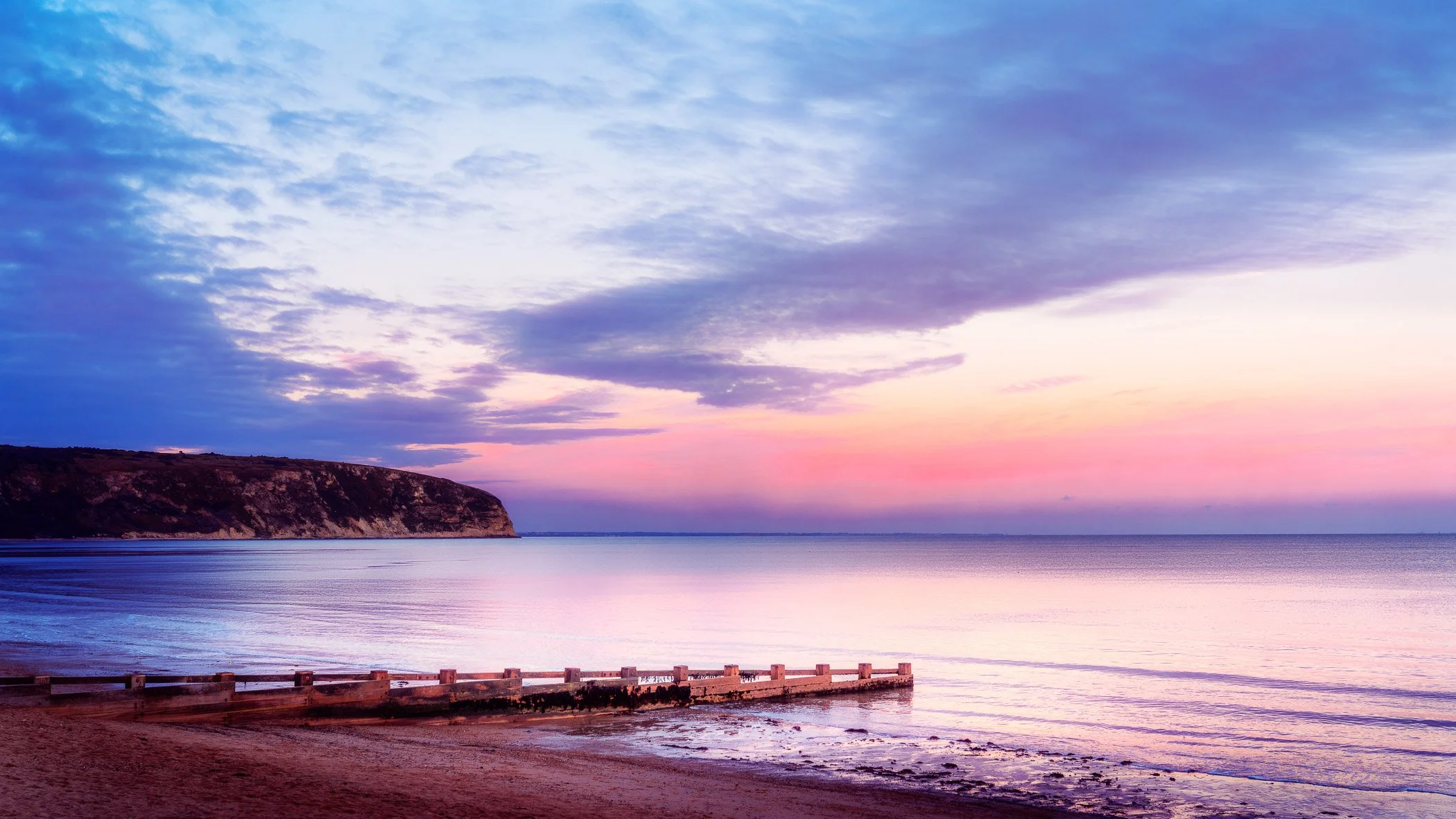 Tranquil Sunset at Swanage Beach A calming evening beach scene featuring gentle waves washing over soft sands bathed in warm sunset light.