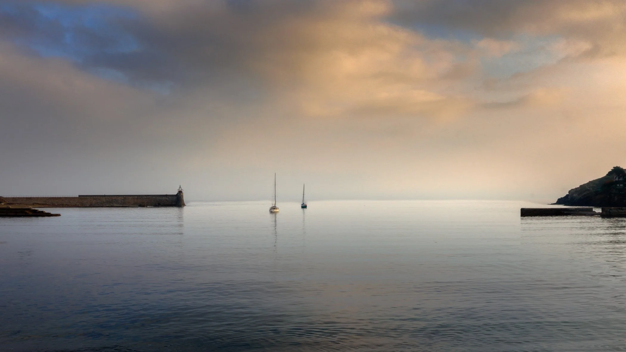 Collioure Harbour A scenic view capturing the historic harbour of Collioure with traditional fishing boats resting along the peaceful shore.